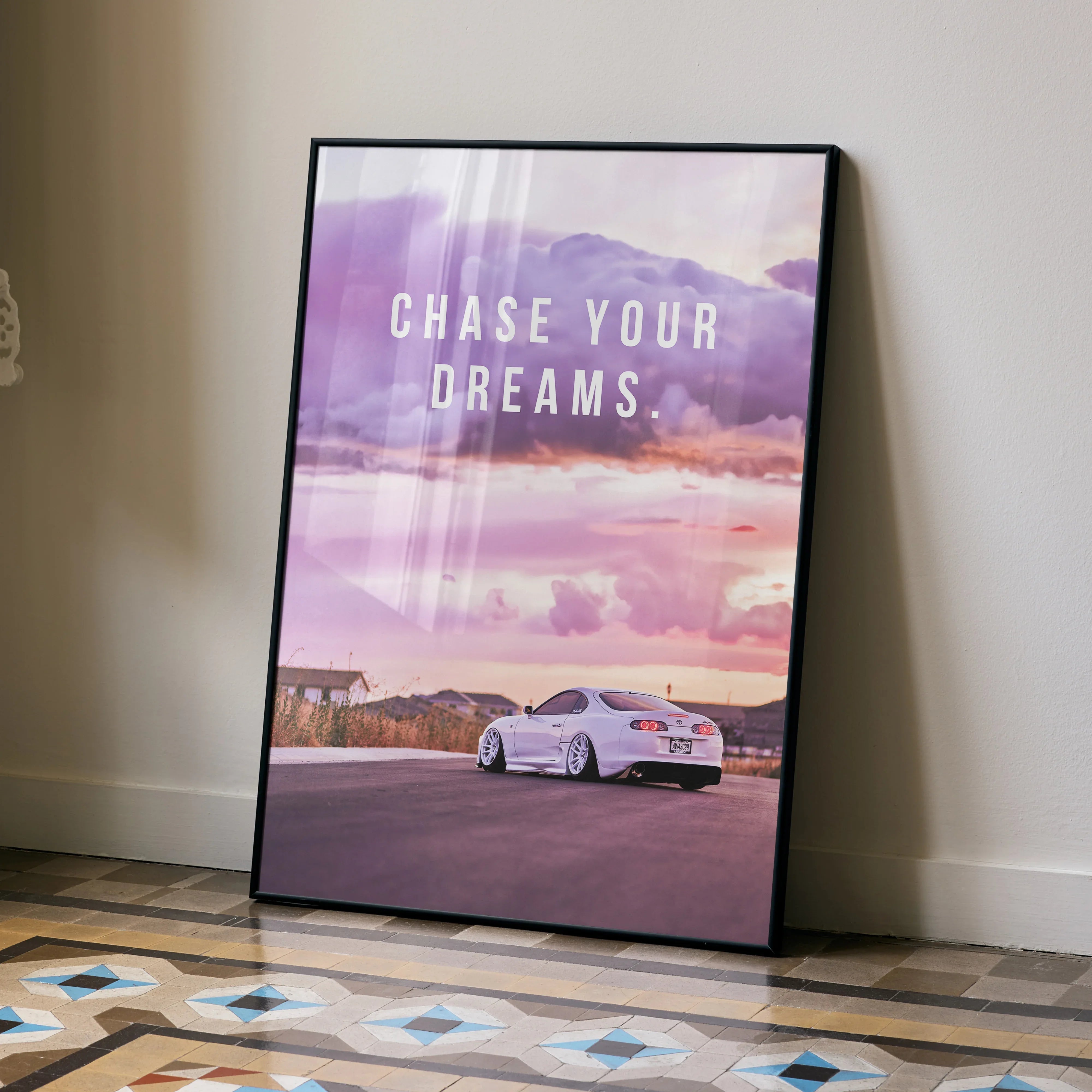 Motivational poster with Toyota Supra Mk4 under purple and pink sky, wall art with "Chase Your Dreams" text.