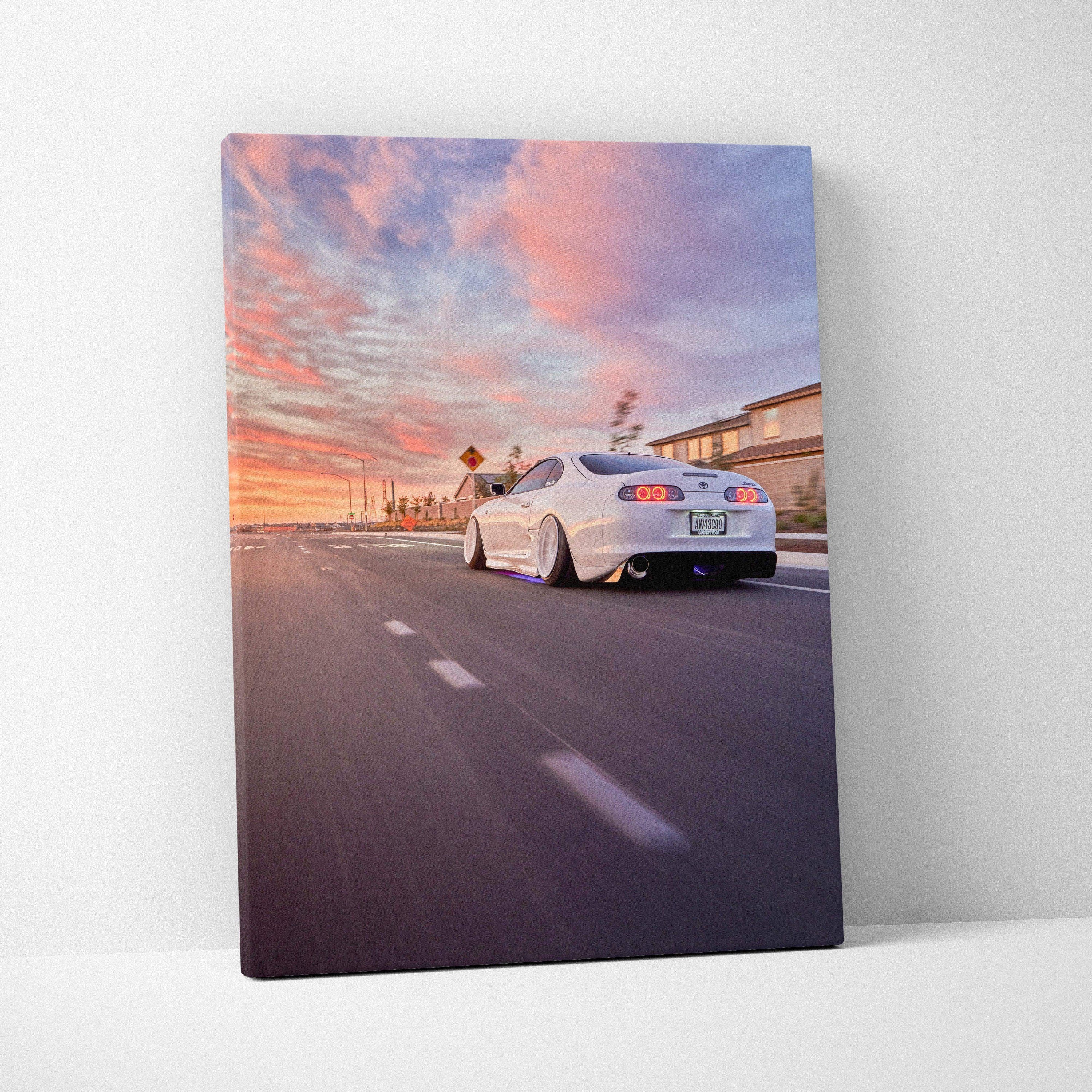 Toyota Supra MK4 driving at sunset with vibrant sky on vertical canvas wall art.