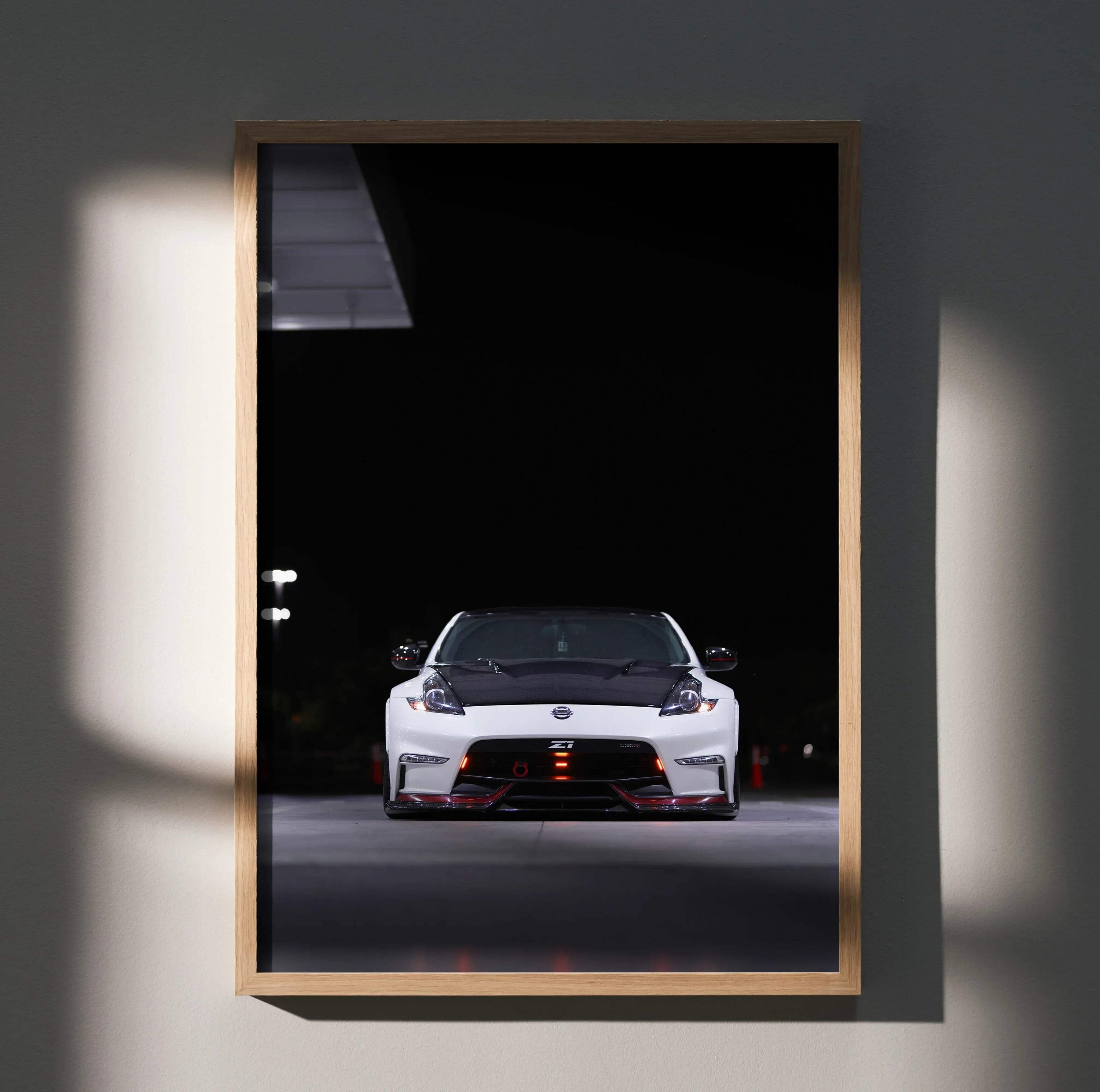 Nissan 370z front view poster with black background, sleek white car wall art in wooden frame.