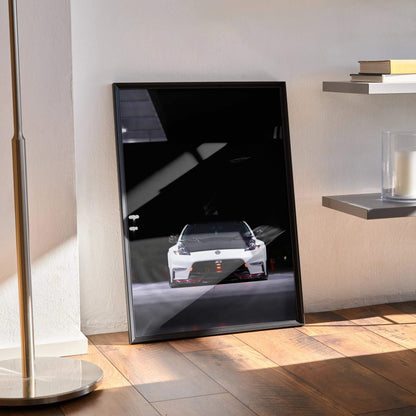 Nissan 370z poster wall art with glossy black frame showcasing front view of the car in shadow and light contrast.