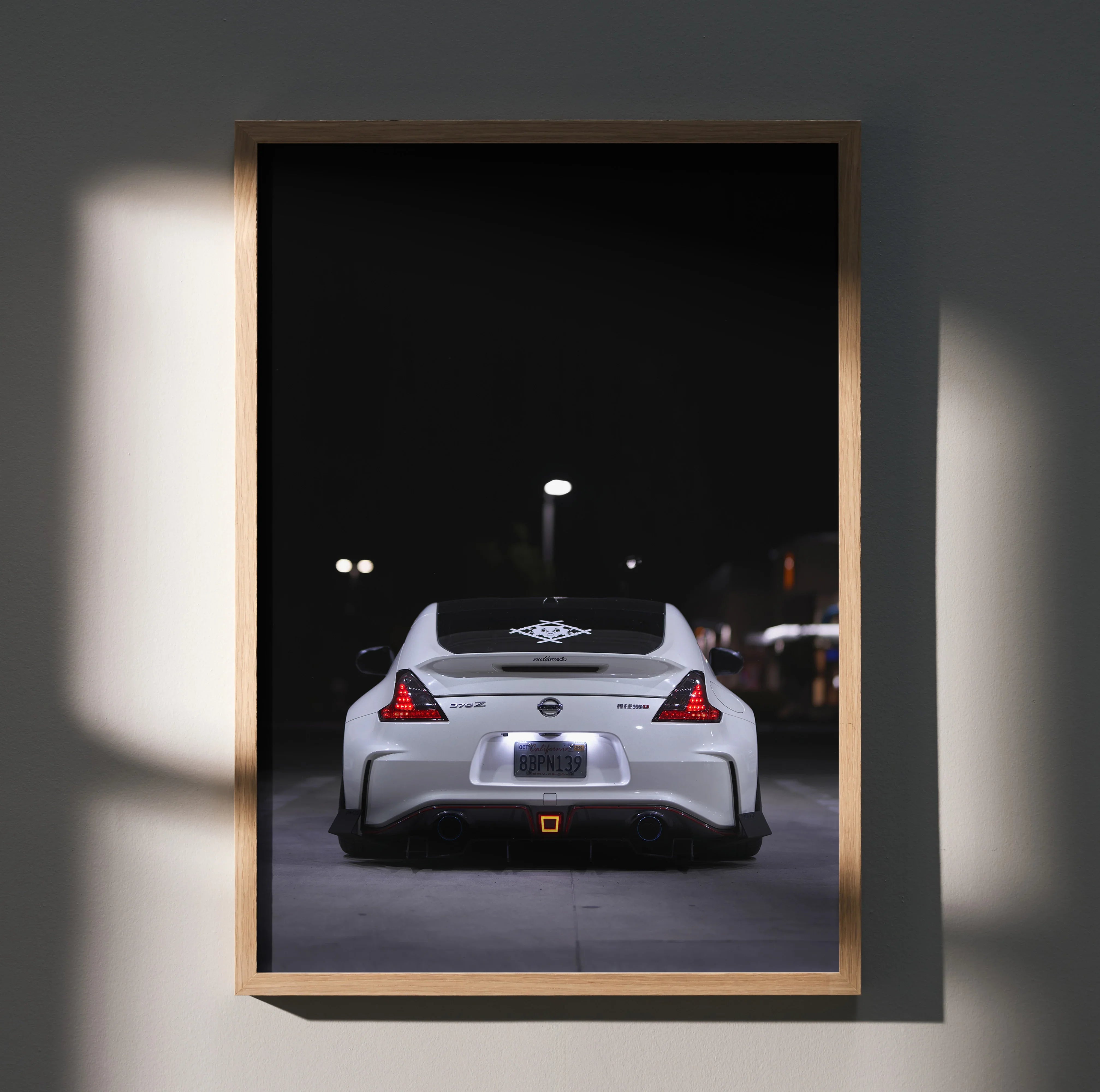 Nissan 370z rear view at night poster wall art with sleek white sports car and dark background.