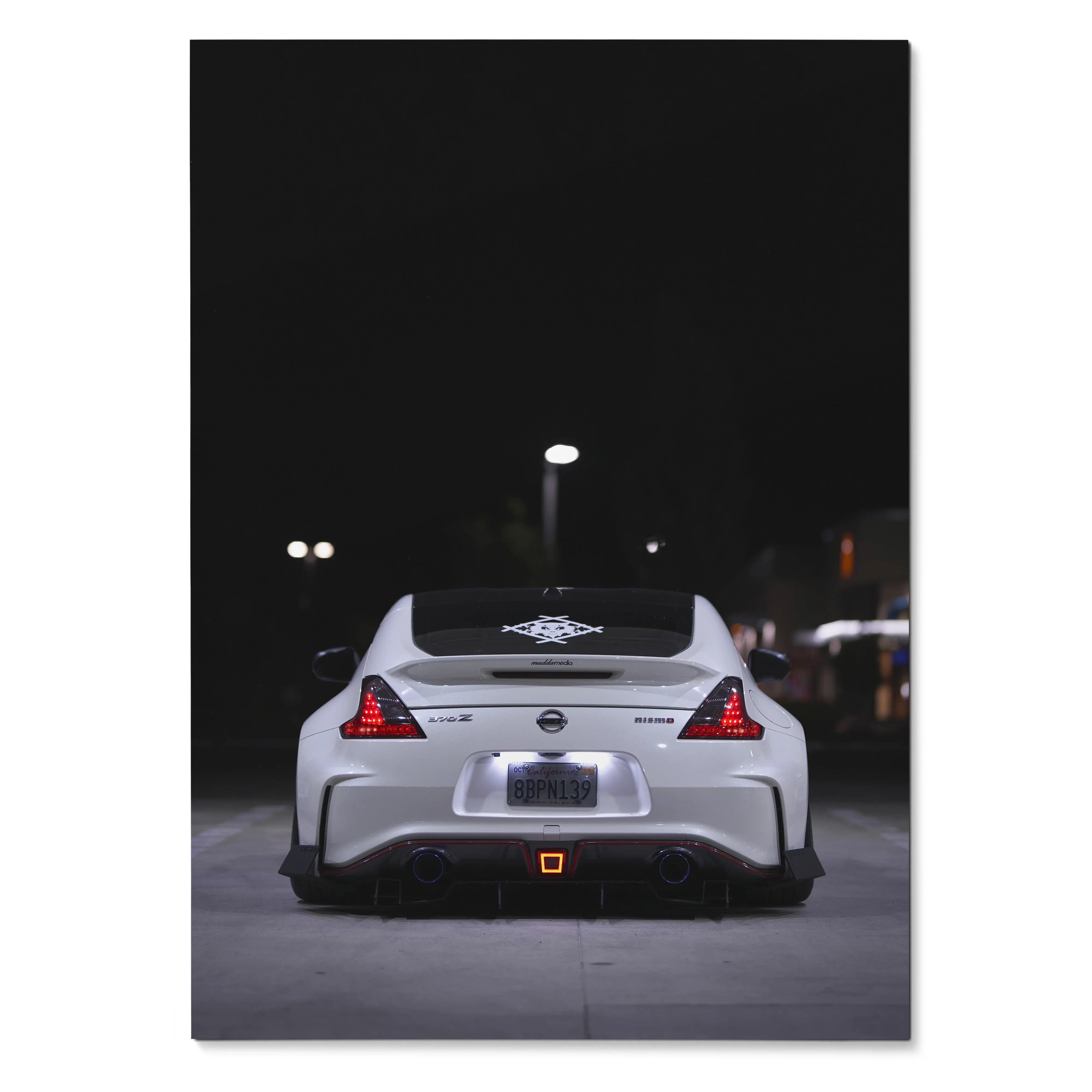 White Nissan 370z rear view at night poster wall art with lit taillights and dark background.