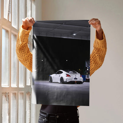 Nissan Z34 370z white sports car night scene poster wall art held against window light.