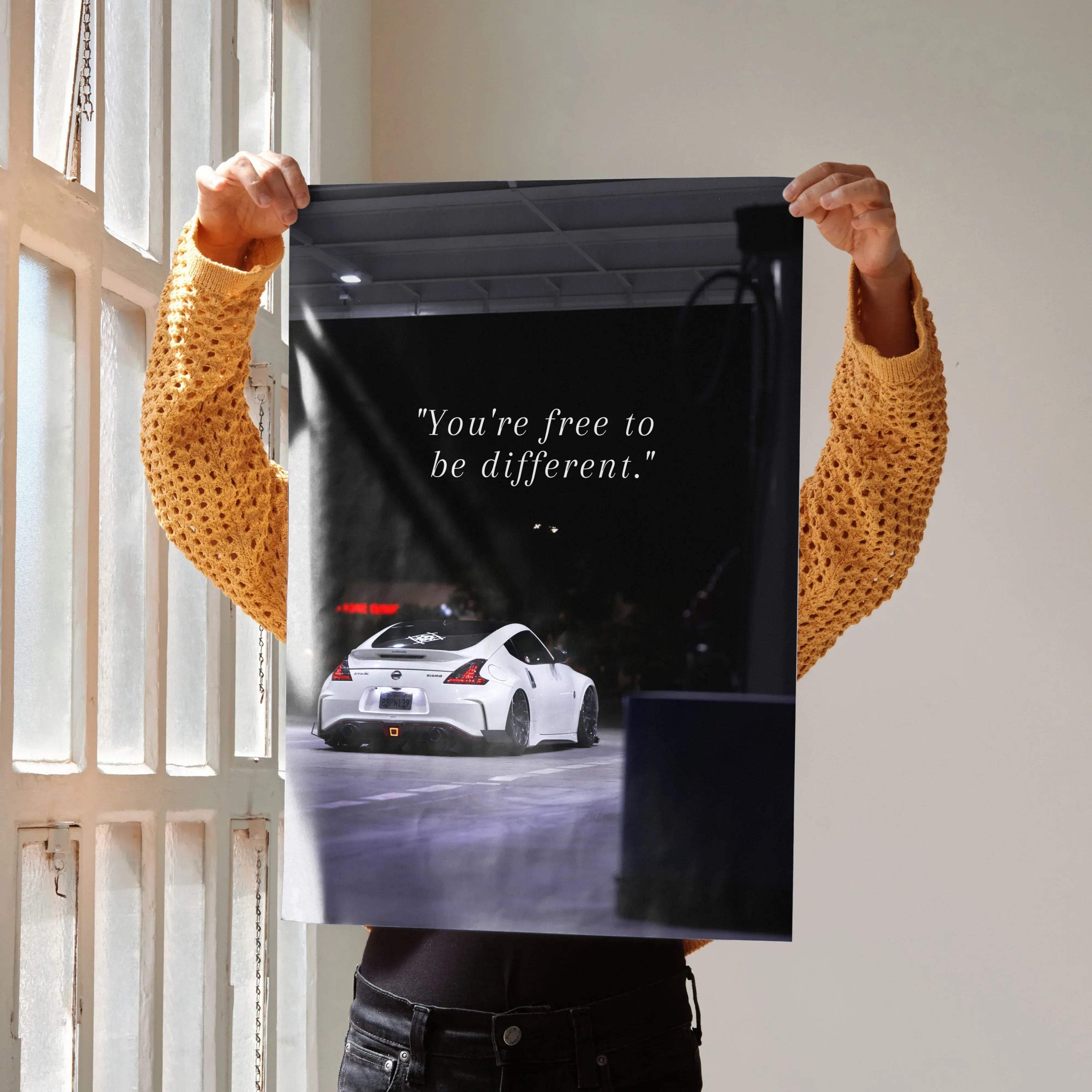 Motivational poster with white Nissan 370z and inspiring text on black background wall art.