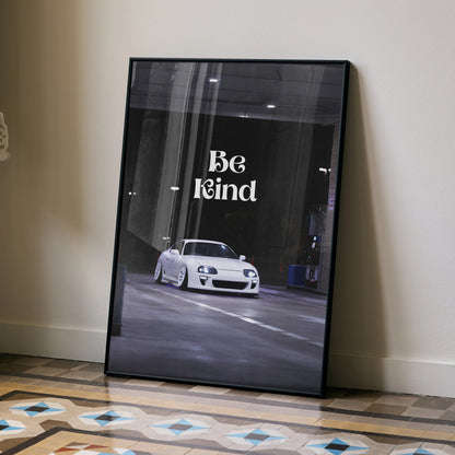 Motivational wall art poster featuring a white Toyota Supra Mk4 with "Be Kind" text on dark urban background.