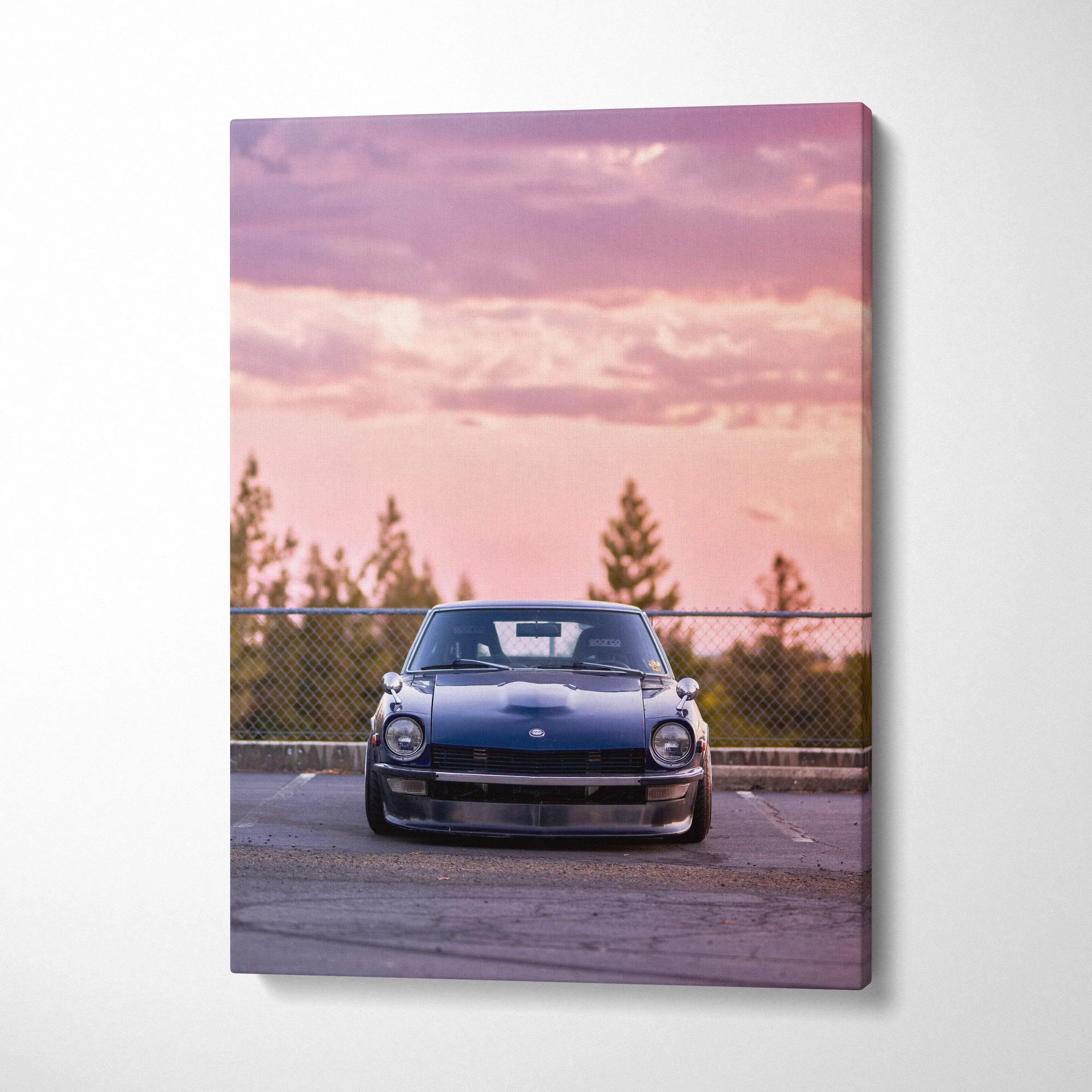 Vertical canvas art of a black Nissan 240z parked at sunset with pink sky and trees in background.