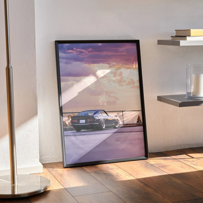 Nissan 240z car poster with sunset sky in black frame leaning against wall wall art.