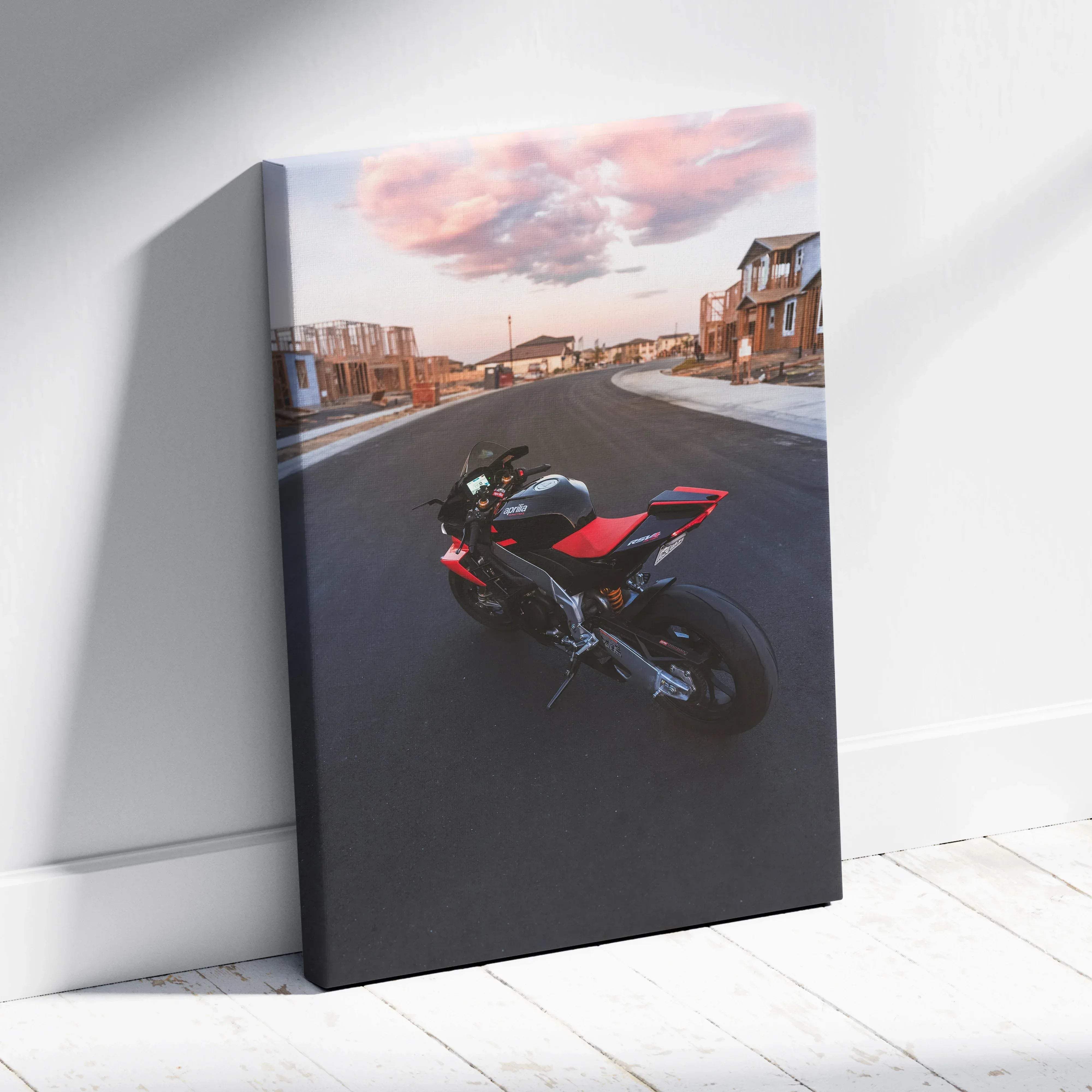 Canvas wall art featuring a black and red aprilia RSV4 1100 factory sport motorcycle in a dynamic street scene