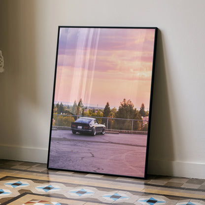 Nissan 240z car poster leaning against wall with sunset sky and trees background wall art.