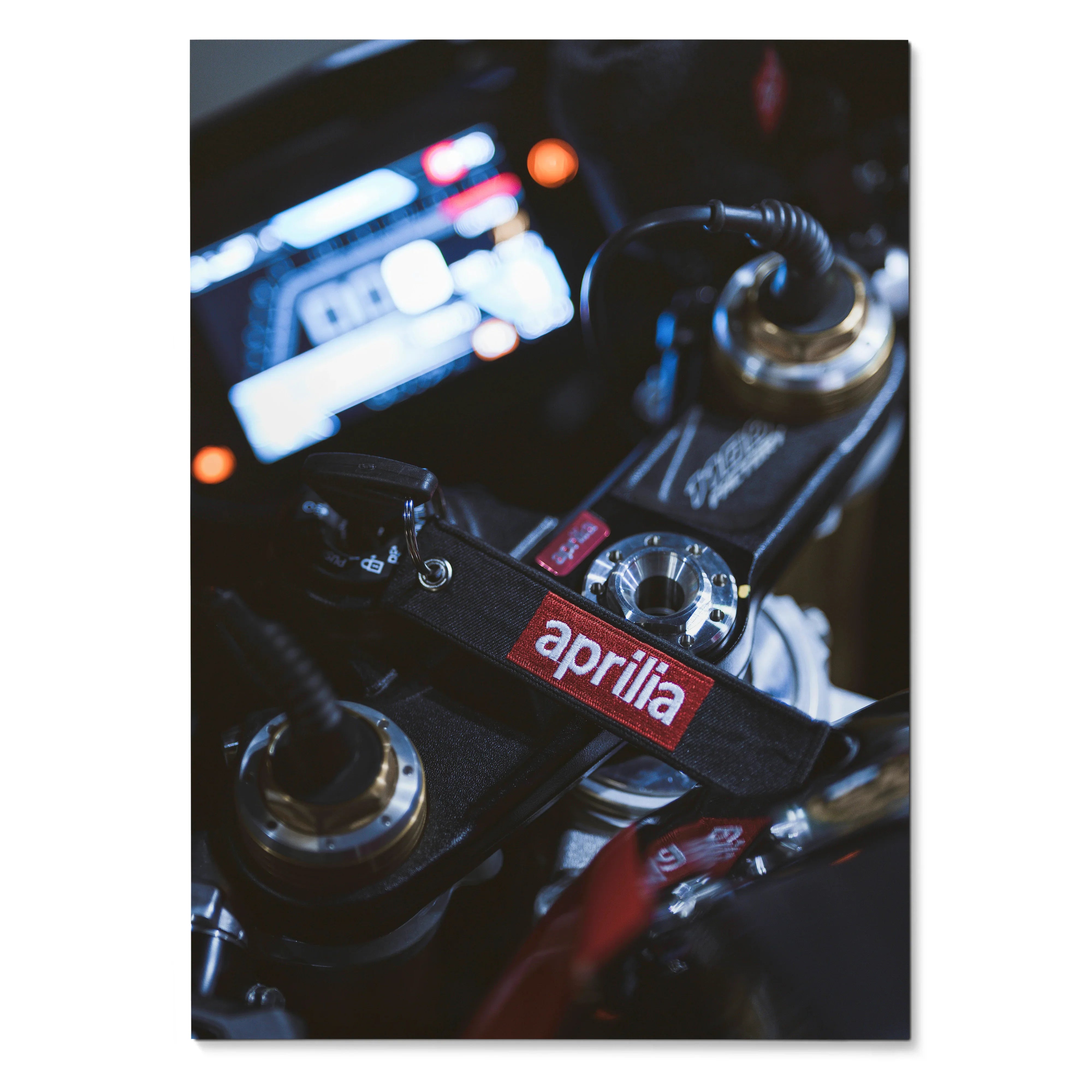 Aprilia RSV4 key fob on motorcycle handlebars poster wall art with dark blurred background.