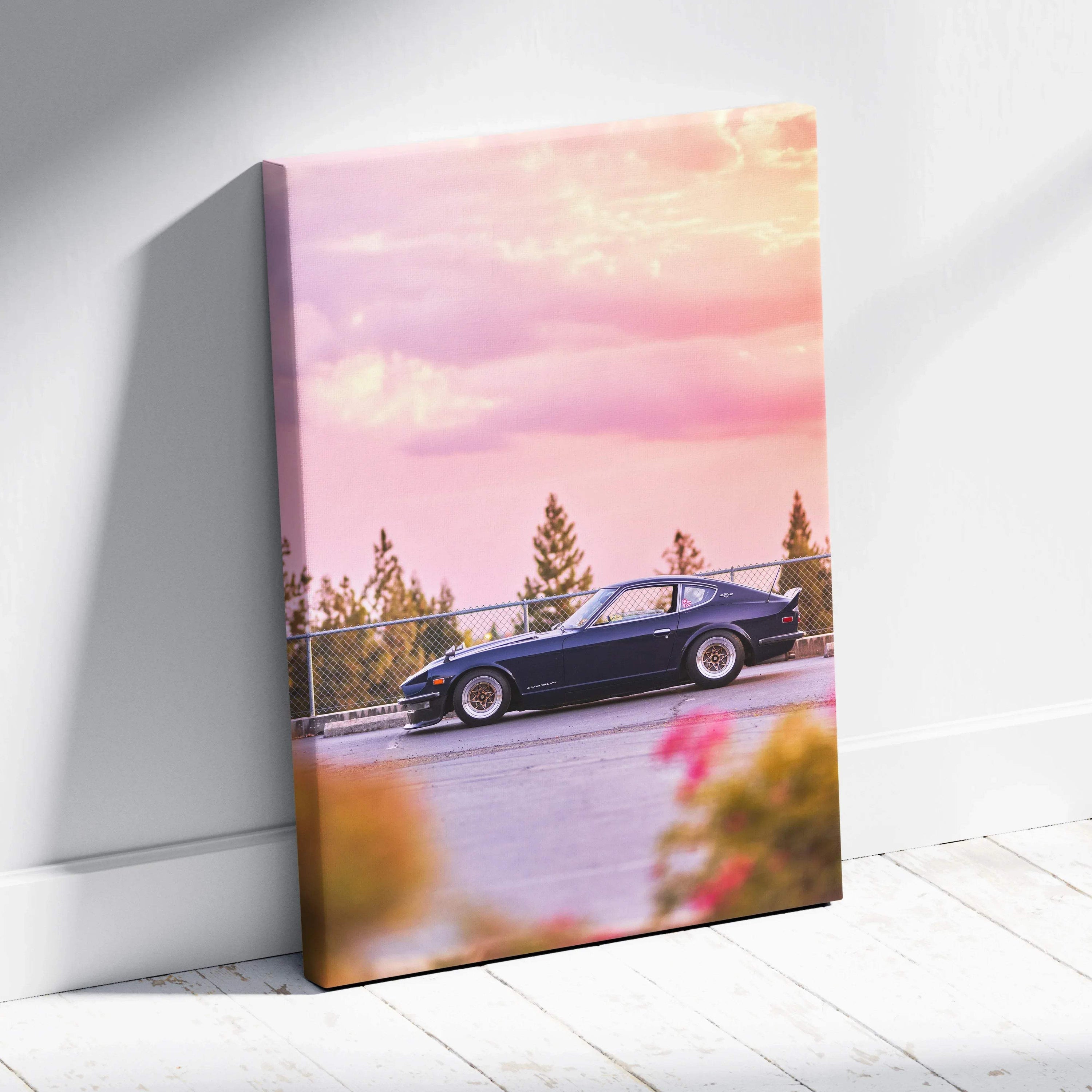 Vertical canvas wall art of a classic black Nissan 240z car with a vibrant pink and orange sunset sky backdrop.
