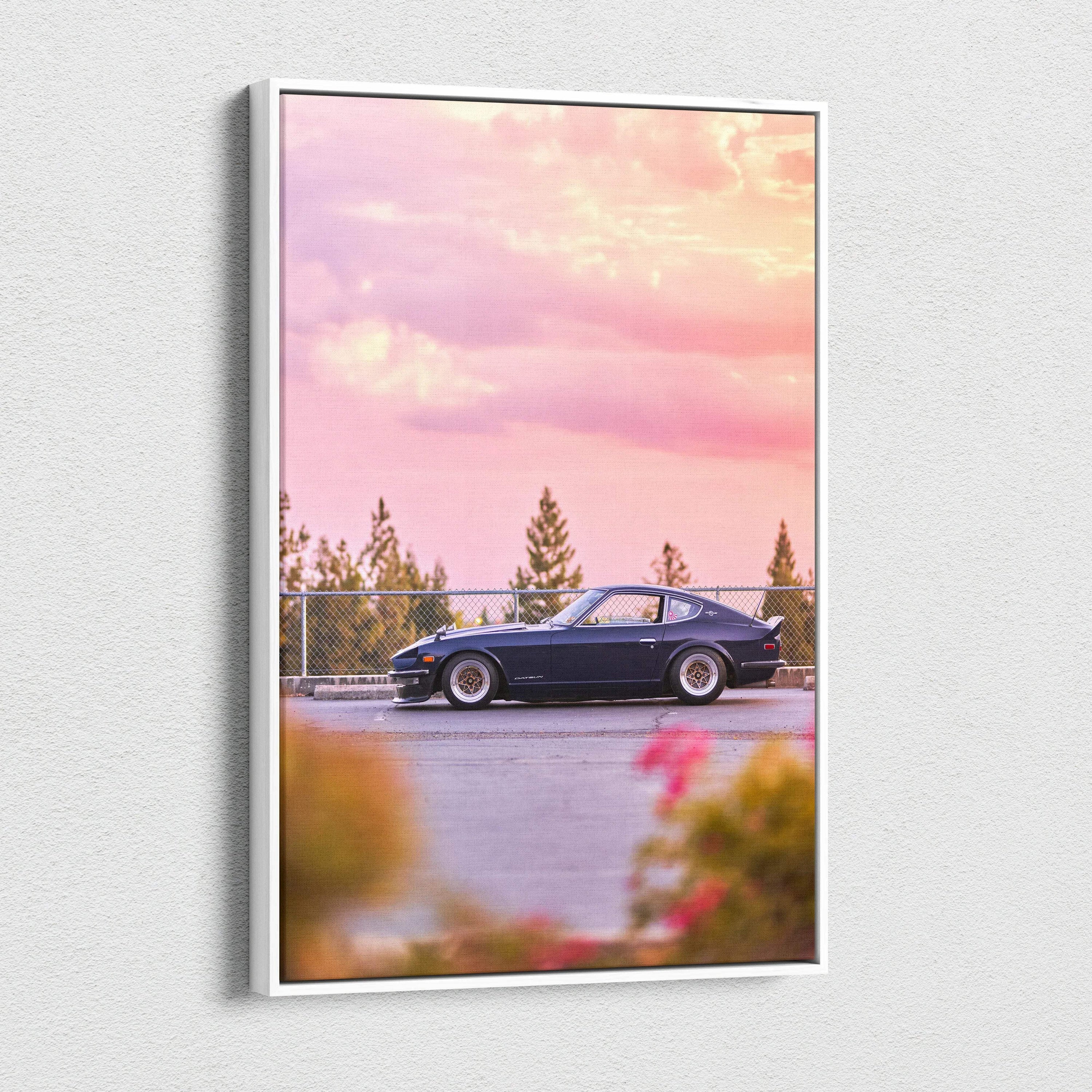 Vertical canvas wall art featuring a black Nissan 240z car against a pink sunset sky with trees in the background.