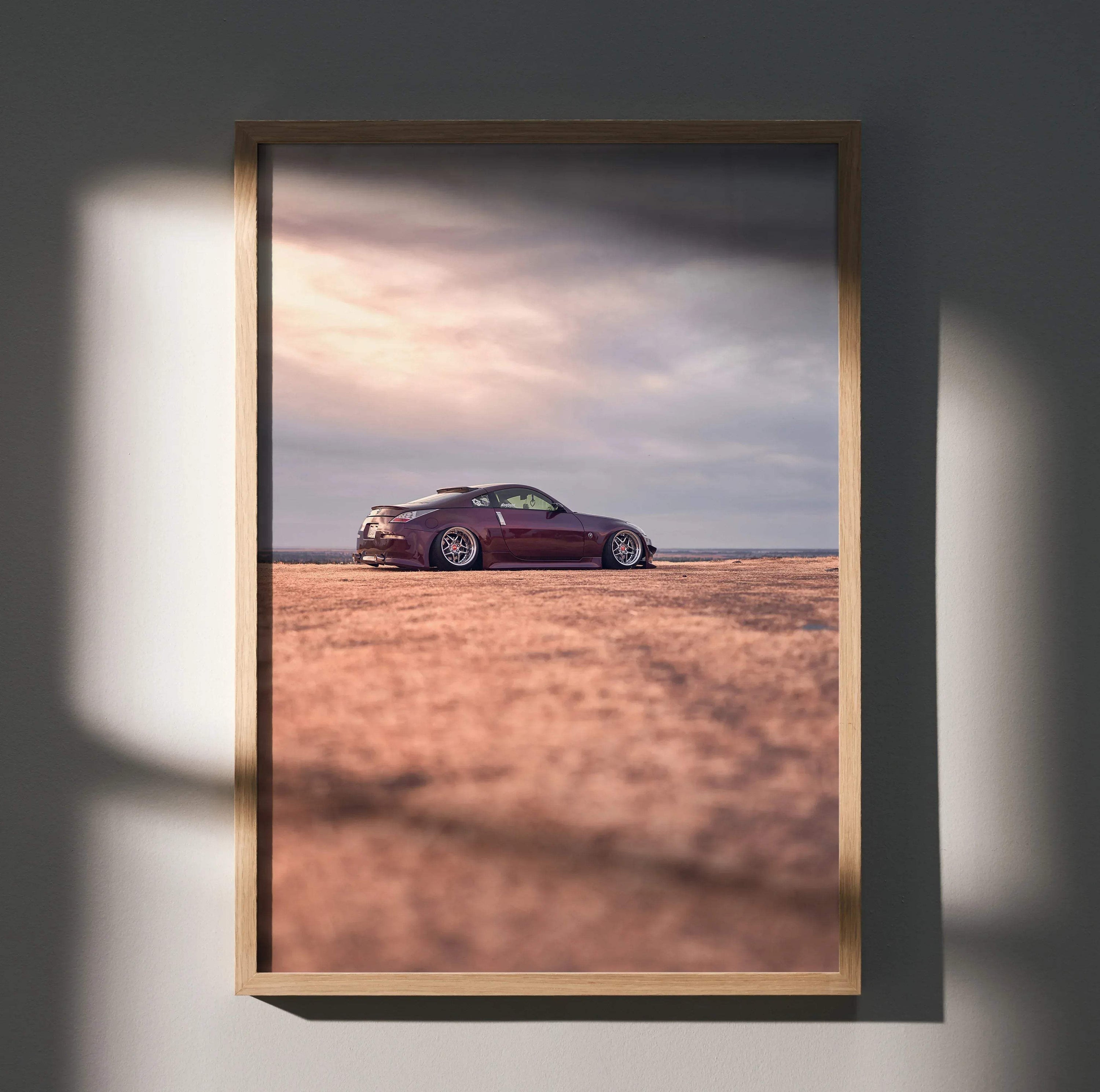 Nissan 350z poster wall art with dark red car on open terrain under cloudy sky.