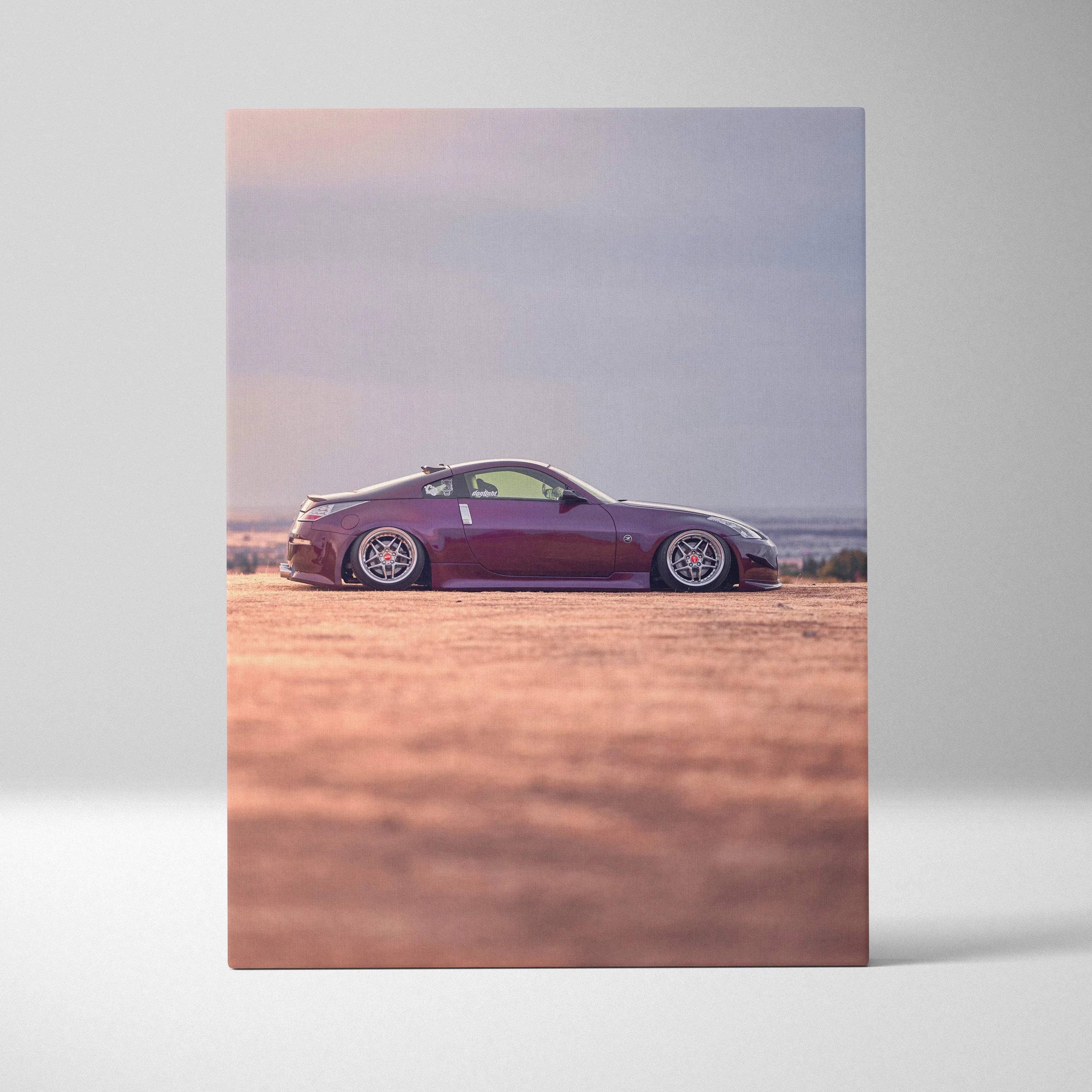 Vertical canvas wall art featuring a maroon Nissan 350z car in a desert landscape at sunset.