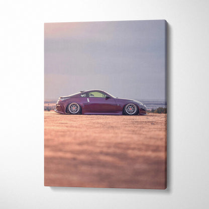 Vertical canvas art of a maroon Nissan 350z parked on a sandy terrain with a soft sky background.