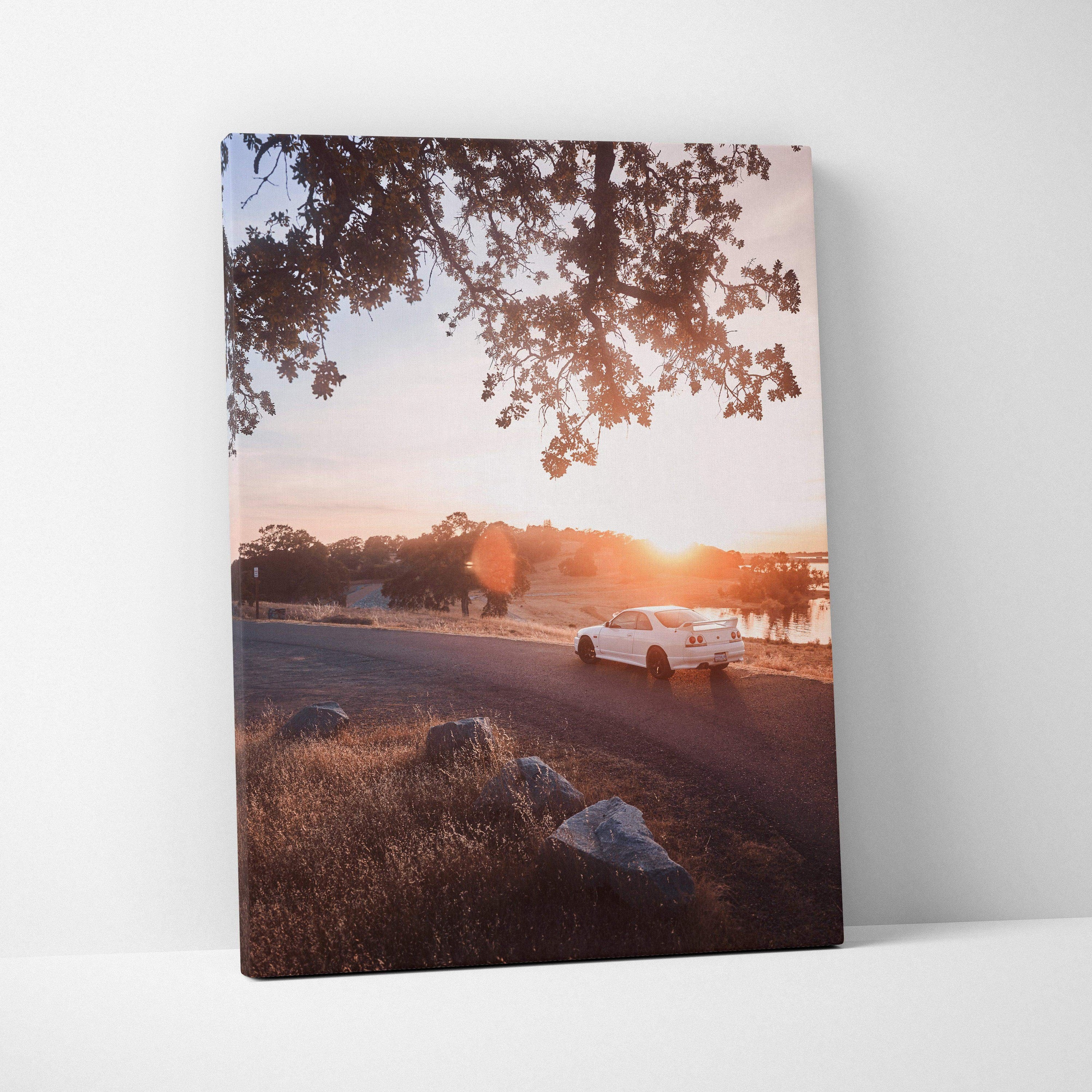 Nissan R33 GTS-T driving at sunset canvas wall art with warm sky and trees background.