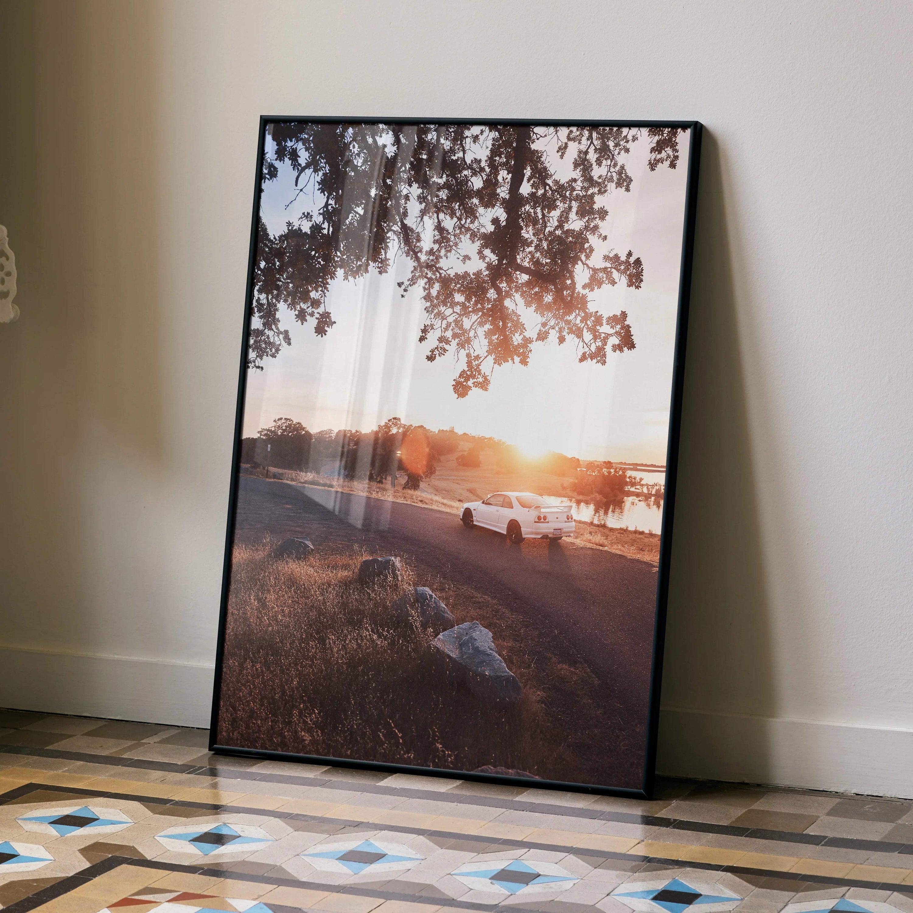 Nissan Skyline R33 GTS-T parked at sunset poster wall art with warm sky and tree branches.