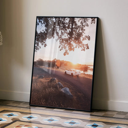 Nissan Skyline R33 GTS-T parked at sunset poster wall art with warm sky and tree branches.