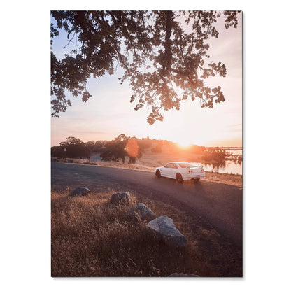 Nissan Skyline R33 GTS-T driving on coastal road at sunset Poster wall art with warm sky tones.