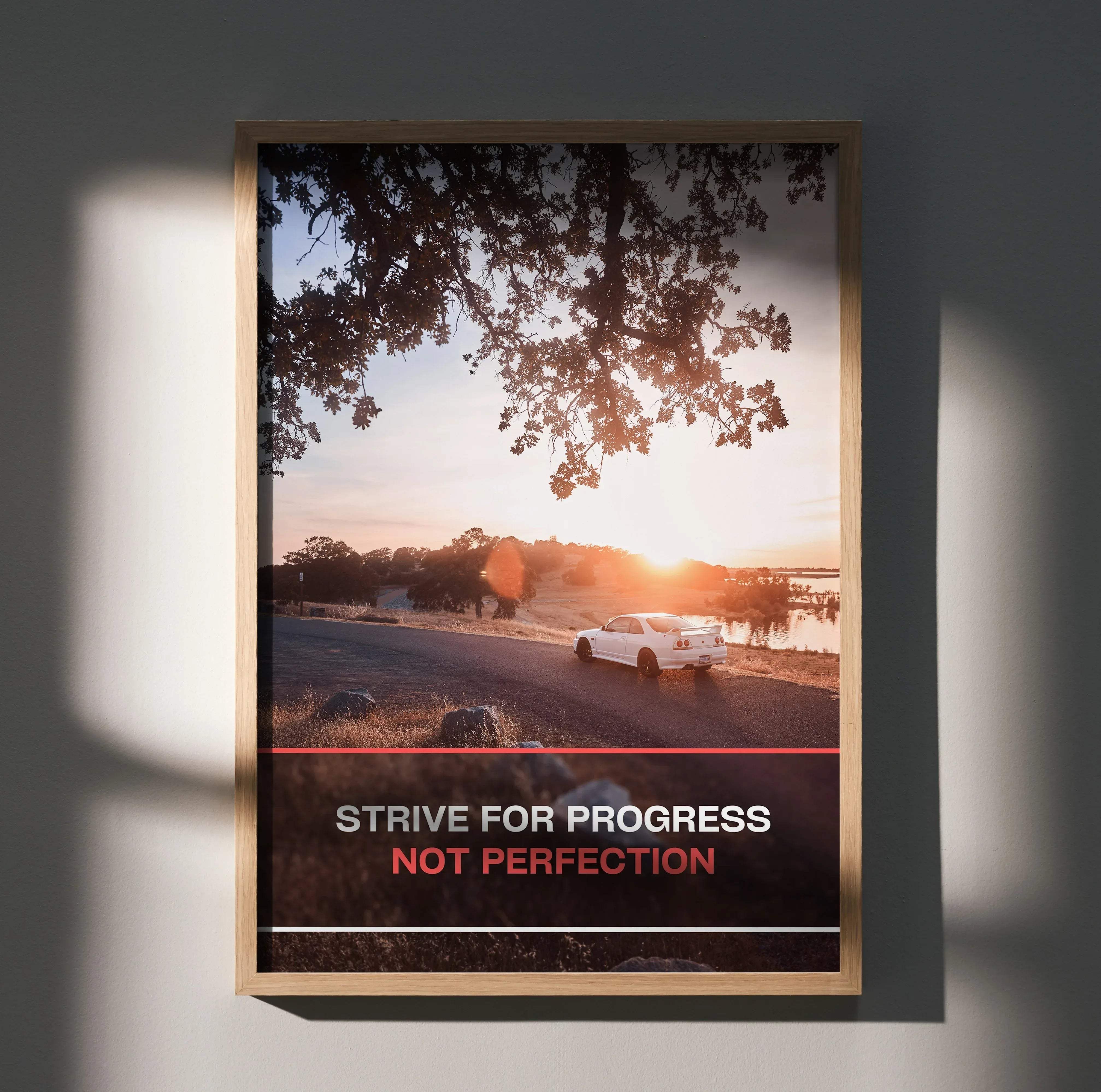 A framed motivational poster featuring a white nissan r33 skyline gts-t driving at sunset with inspiring text