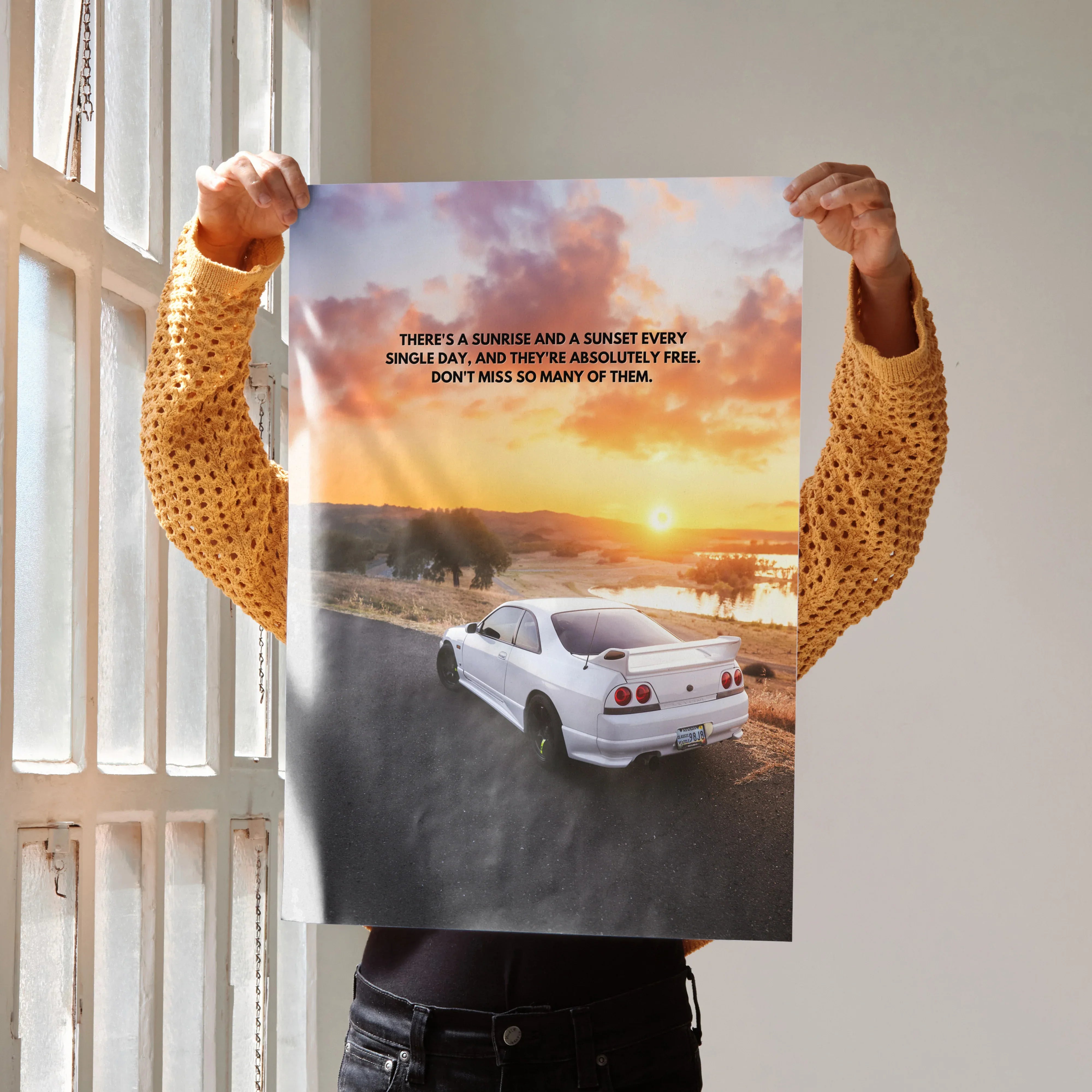 Motivational poster wall art featuring white Nissan R33 Skyline GTS-T on sunset road with inspiring quote.