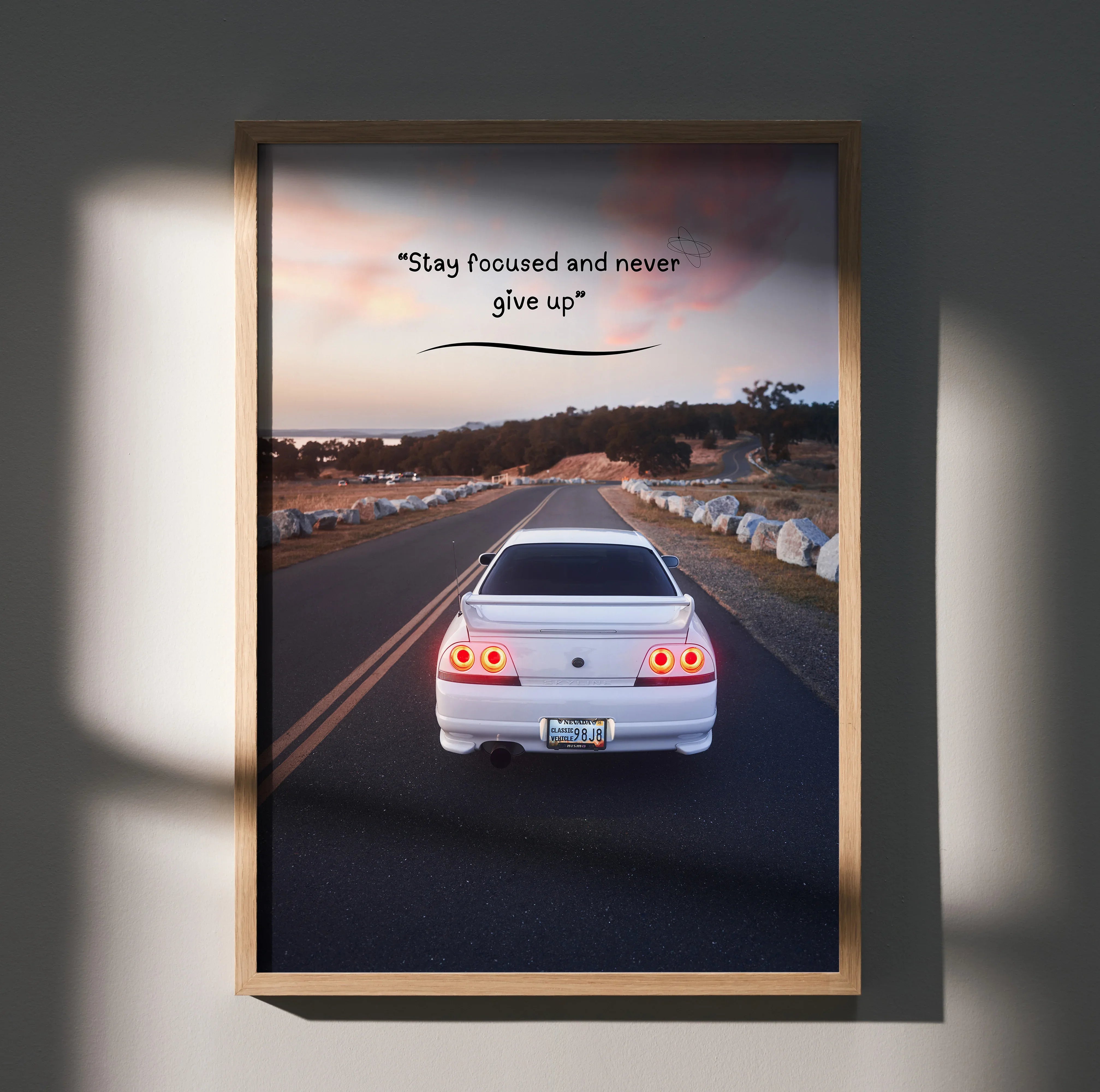 Motivational poster wall art featuring rear view of white Nissan R33 Skyline GTS-T on road at sunset with inspiring text.