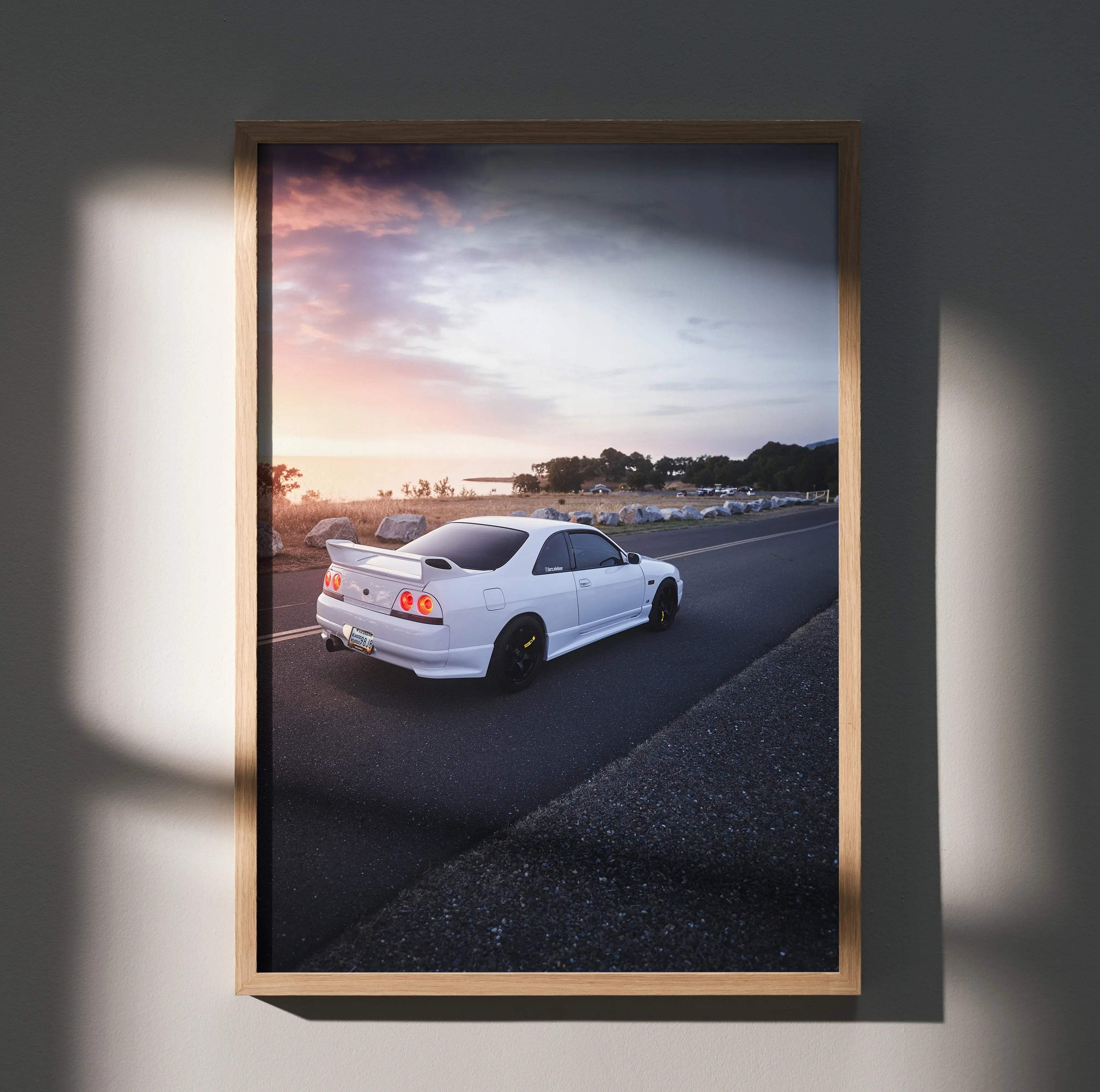 Nissan Skyline R33 GTS-T poster wall art featuring white sports car at sunset on highway.