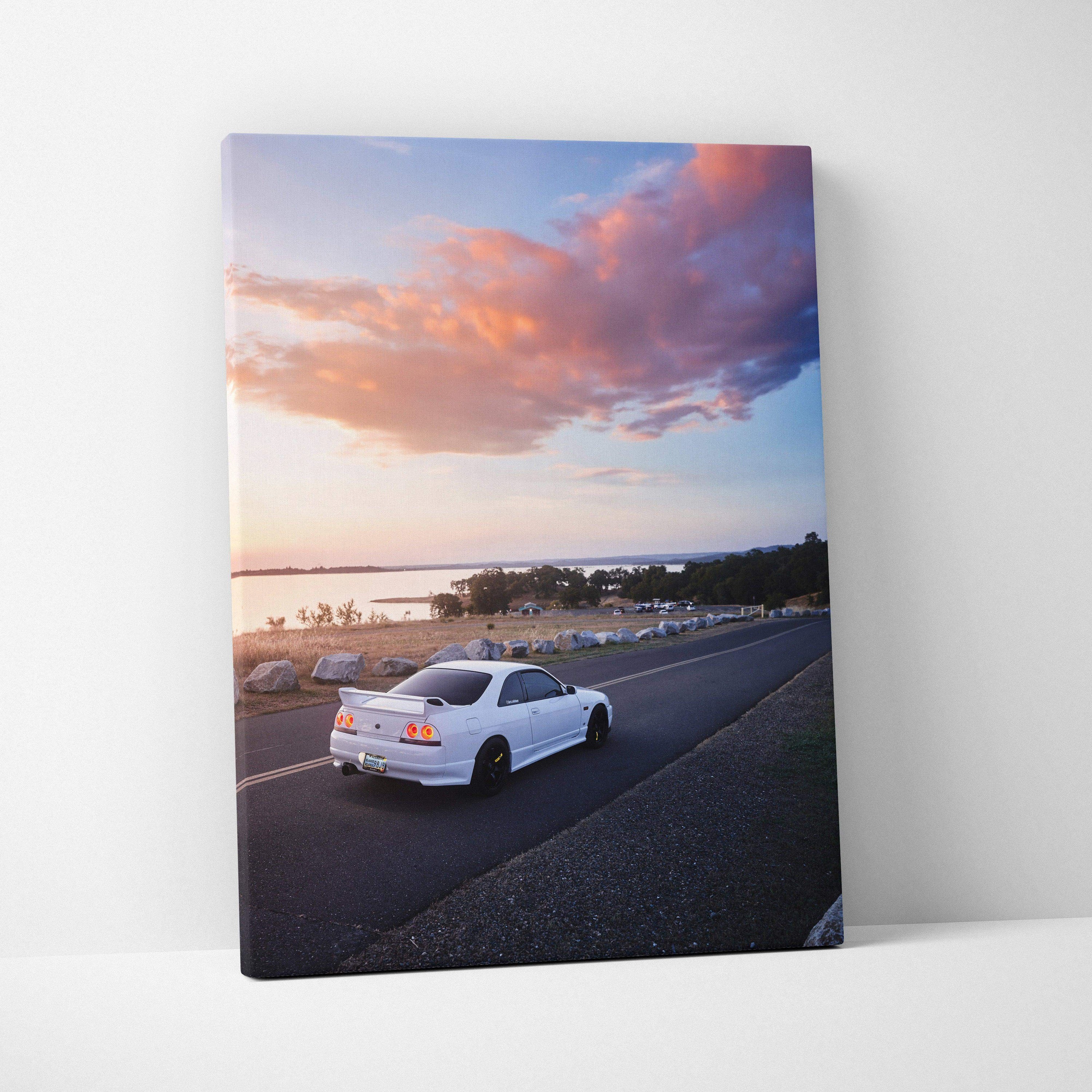 Vertical canvas wall art featuring white Nissan R33 GTS-T driving at sunset with colorful sky.