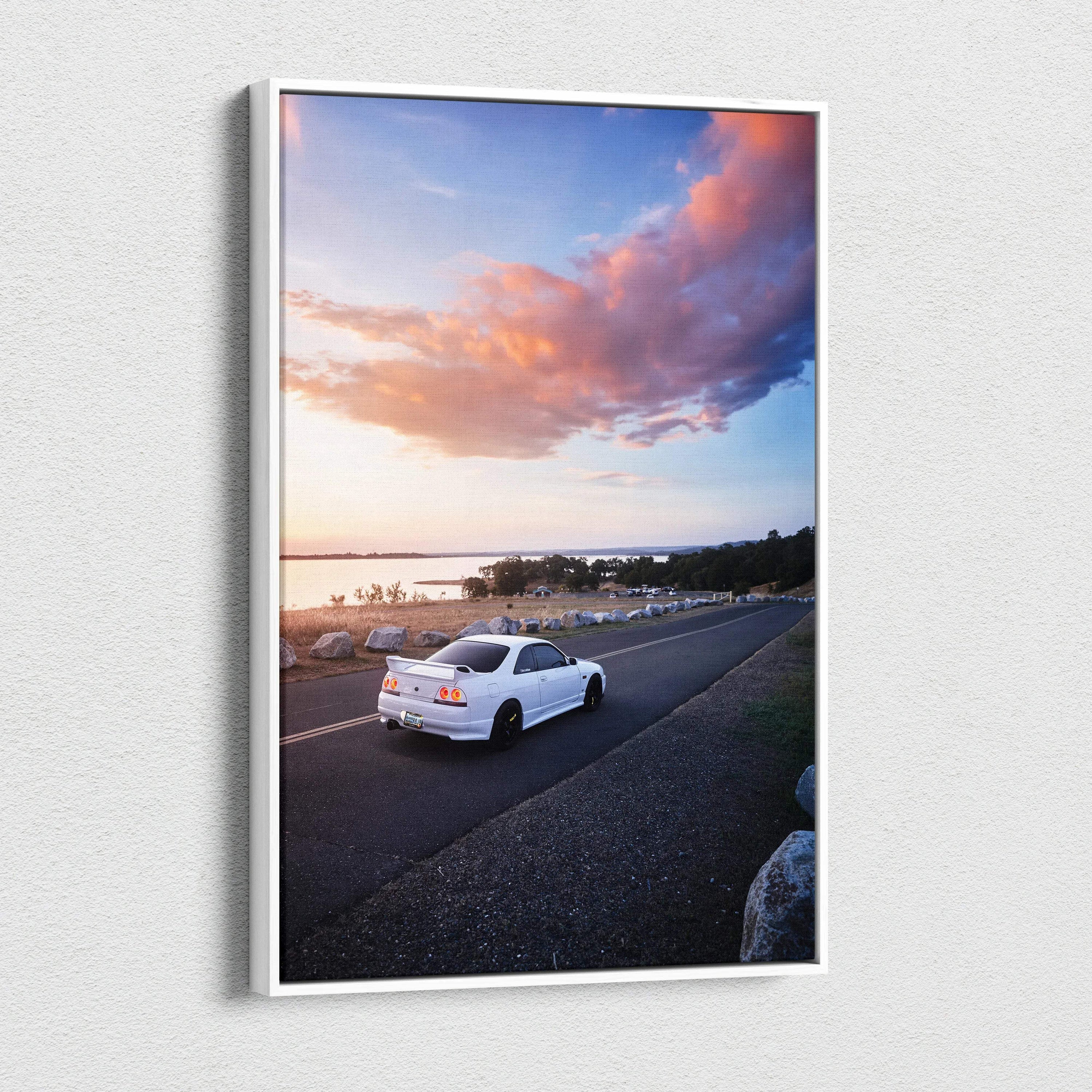 White Nissan R33 GTS-T driving on coastal road at sunset canvas wall art.