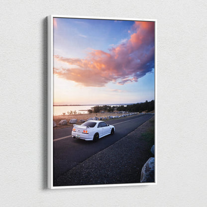 White Nissan R33 GTS-T driving on coastal road at sunset canvas wall art.