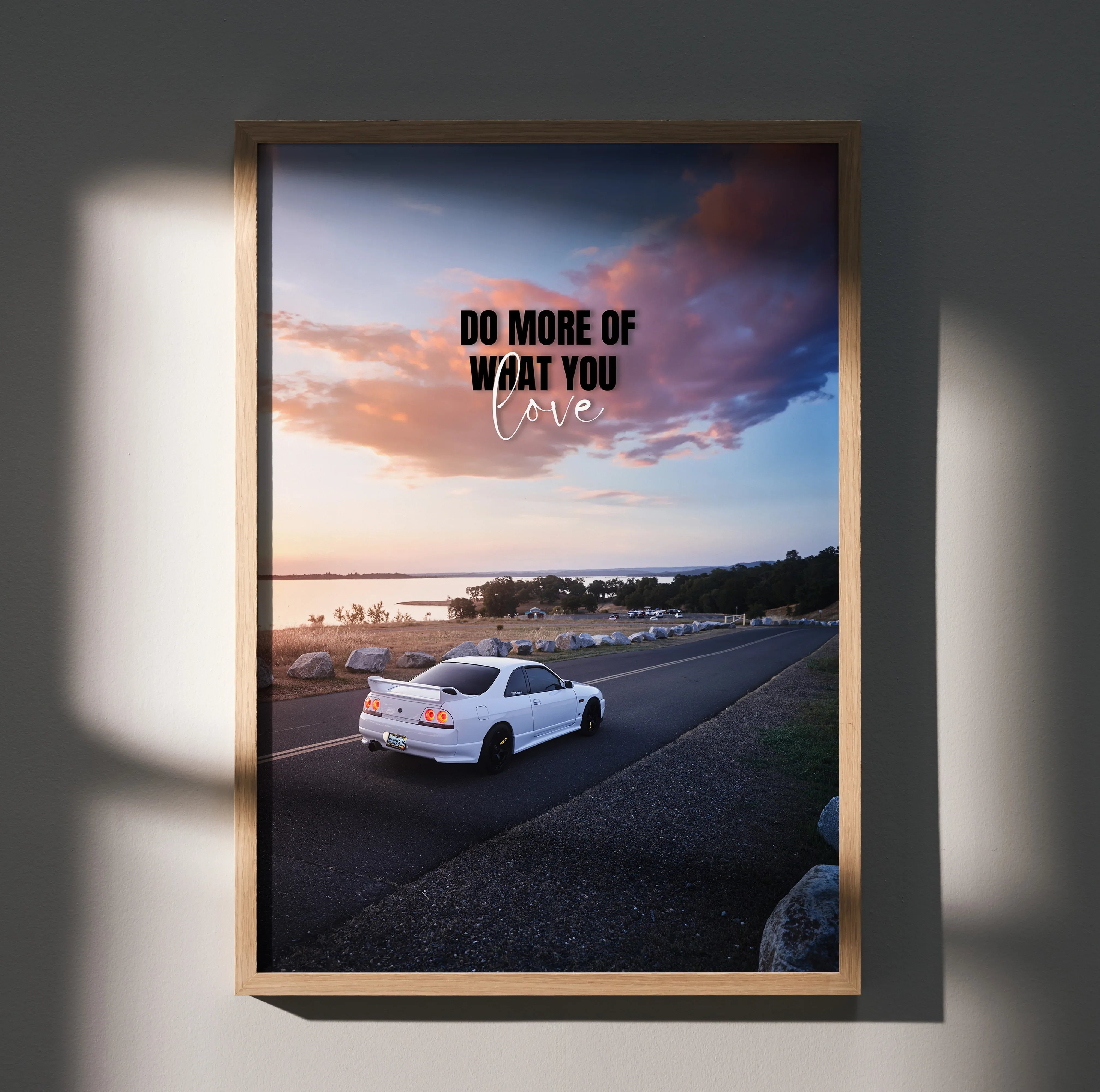 Motivational poster wall art featuring white Nissan R33 Skyline GTS-T on coastal road at sunset.
