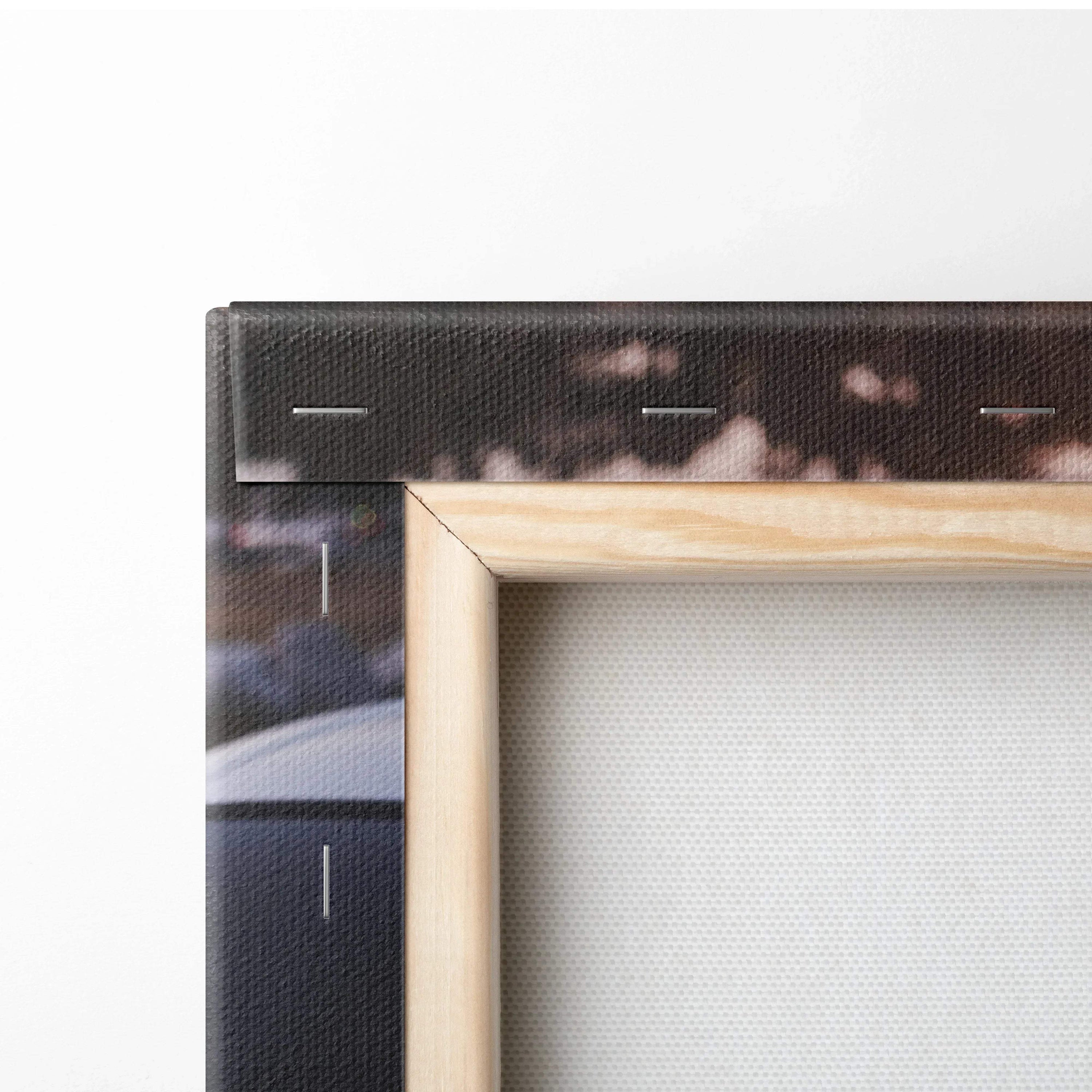 Close-up of natural wood frame corner on vertical canvas wall art with textured woven fabric and dark print edges.