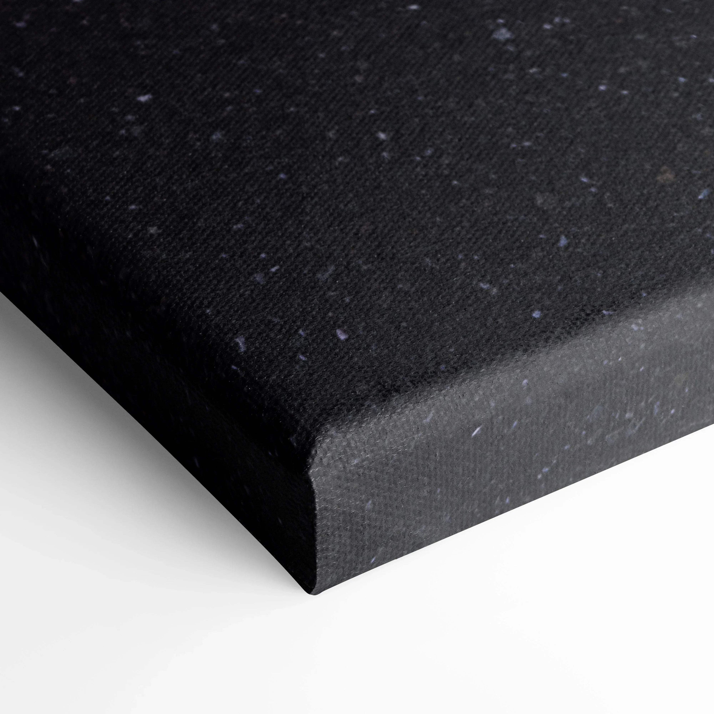 Black speckled canvas corner close-up showcasing textured wall art panel edge.