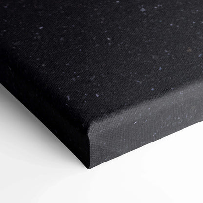 Black speckled canvas corner close-up showcasing textured wall art panel edge.