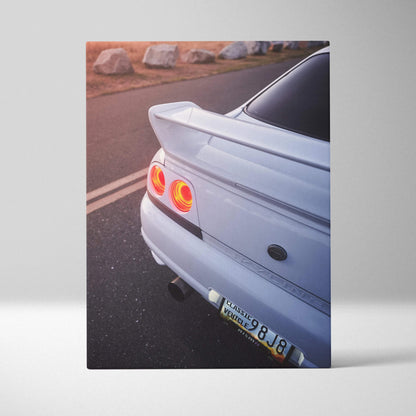 Nissan R33 GTS-T rear view on canvas wall art with vibrant tail lights and road background.