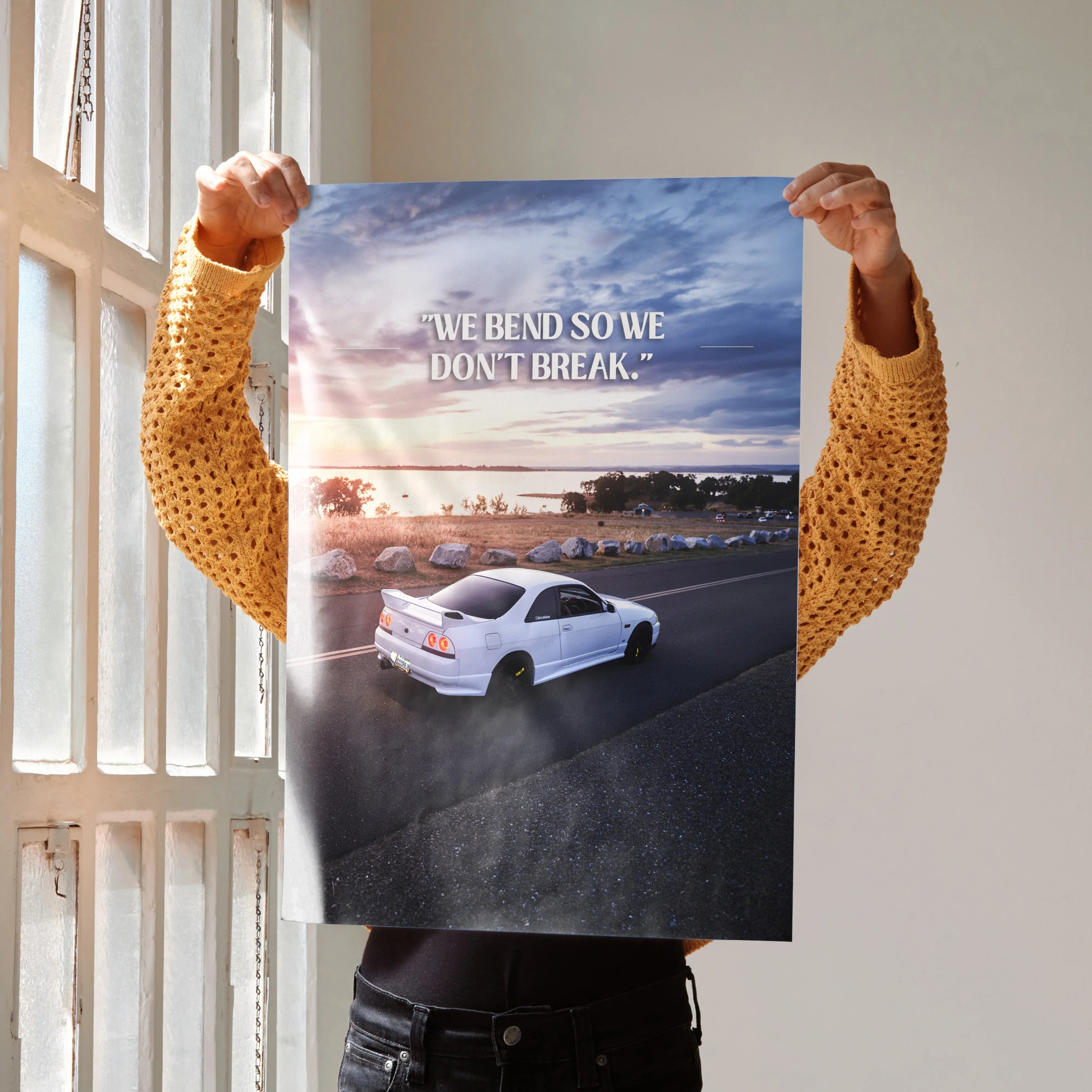 Poster wall art featuring a white Nissan R33 Skyline GTS-T on a coastal road with inspiring text and sunset sky.