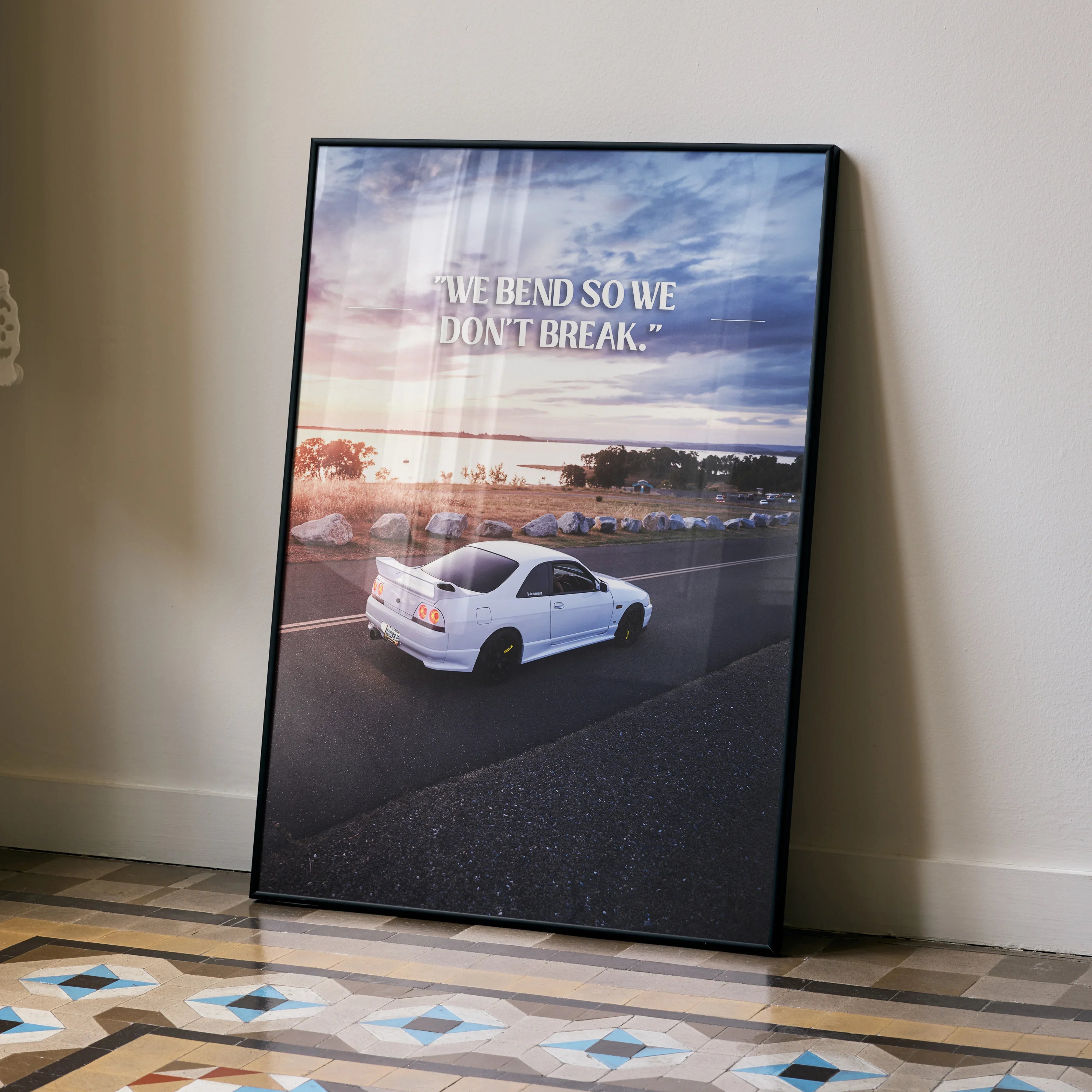 Motivational poster wall art featuring white Nissan R33 Skyline GTS-T with sunset sky and inspiring text.