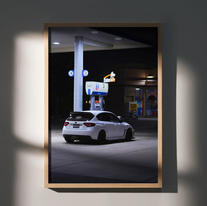 Subaru WRX STI parked at gas station at night poster wall art in wooden frame.