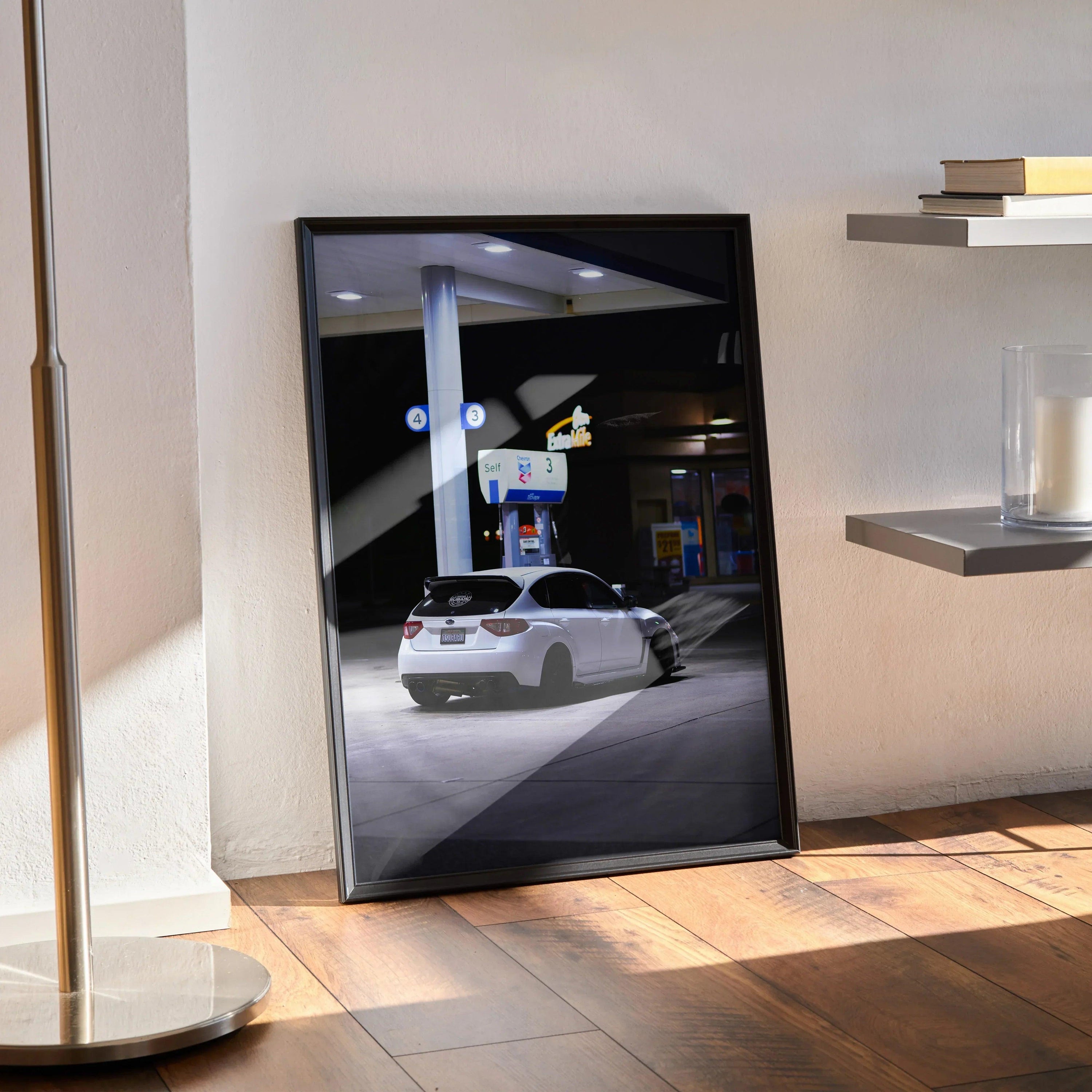 Framed Subaru WRX STI poster wall art showing rear view of white car at night gas station.