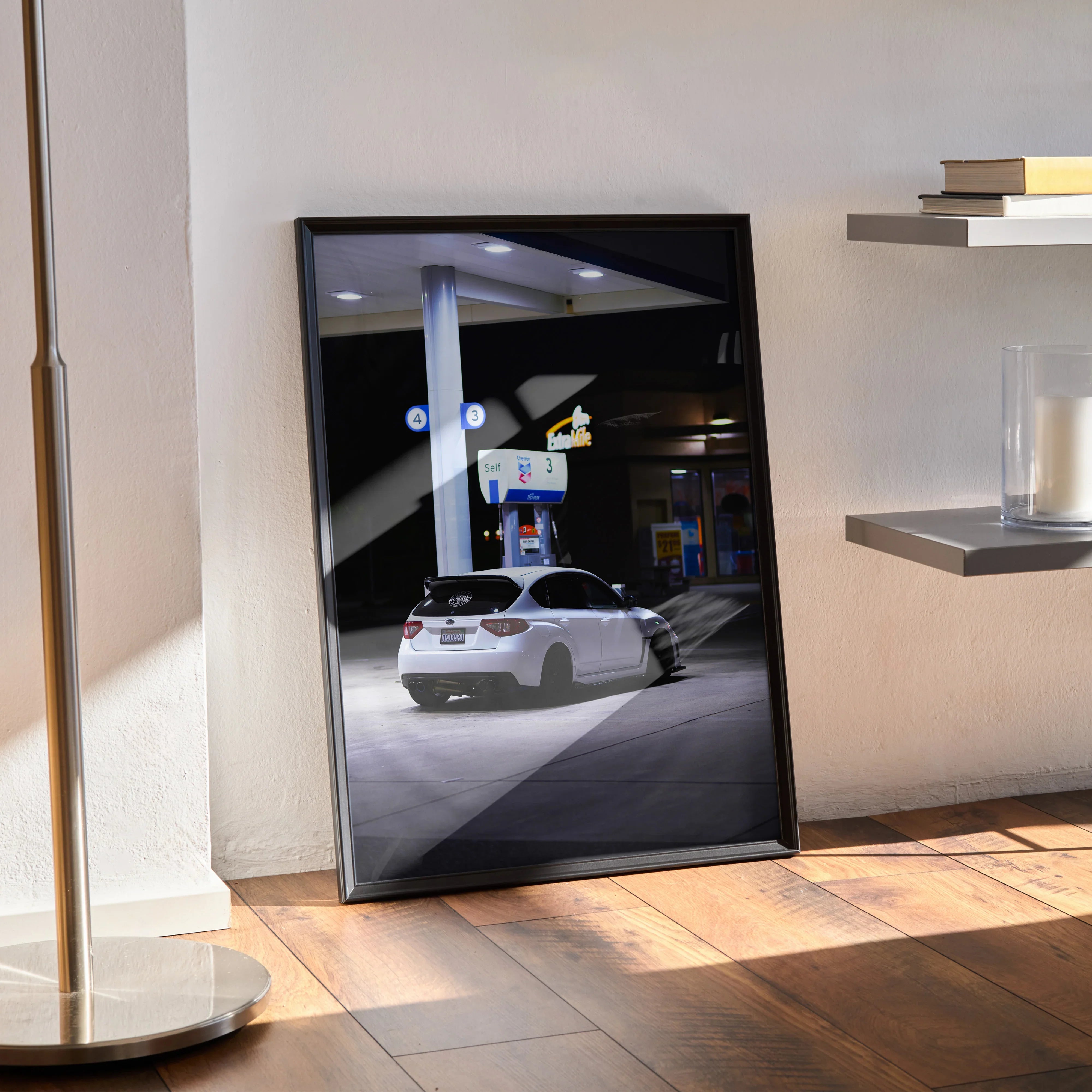 Framed Subaru WRX STI poster wall art showing rear view of white car at night gas station.