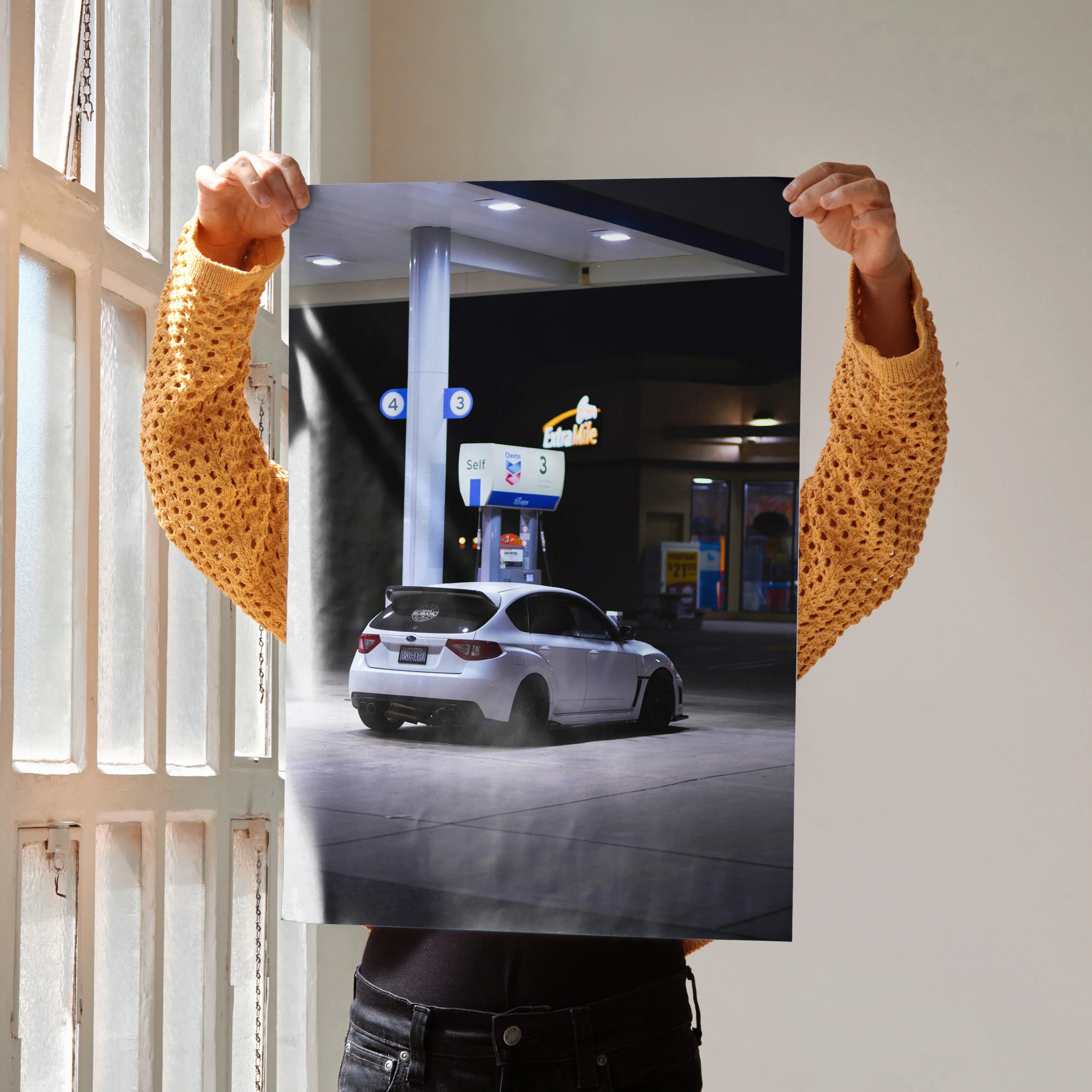 Subaru WRX STI poster wall art showing white car at nighttime gas station in urban setting.