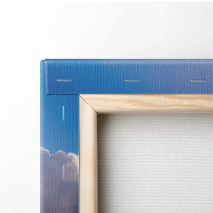 Close-up of wooden frame and canvas edge with blue sky and clouds wall art.