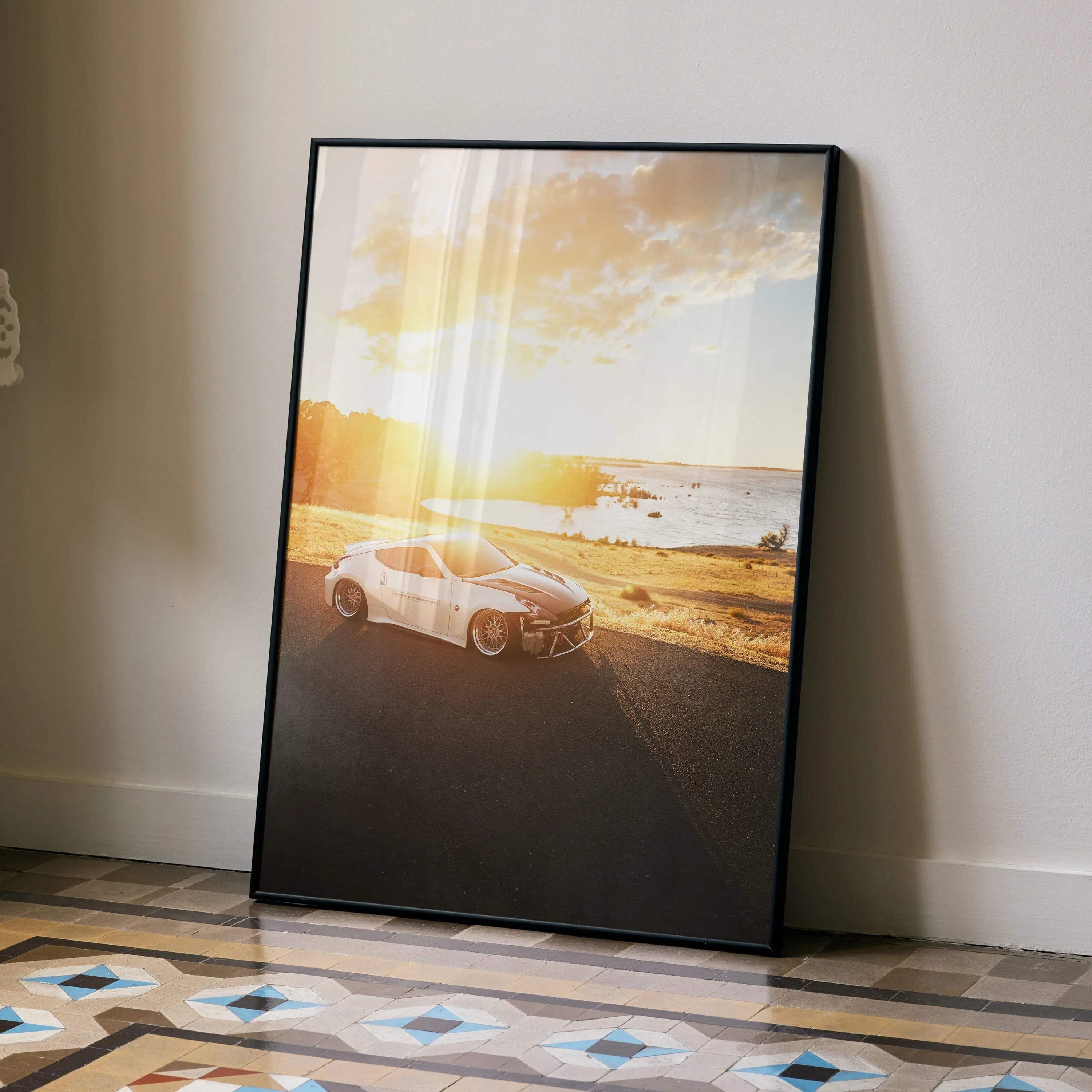 Nissan 370z car poster with sunset beach scene, framed wall art leaning on floor.