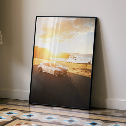 Nissan 370z car poster with sunset beach scene, framed wall art leaning on floor.