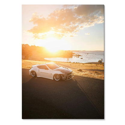 Nissan 370z sports car parked on coastal road at sunset poster wall art with warm sky colors.
