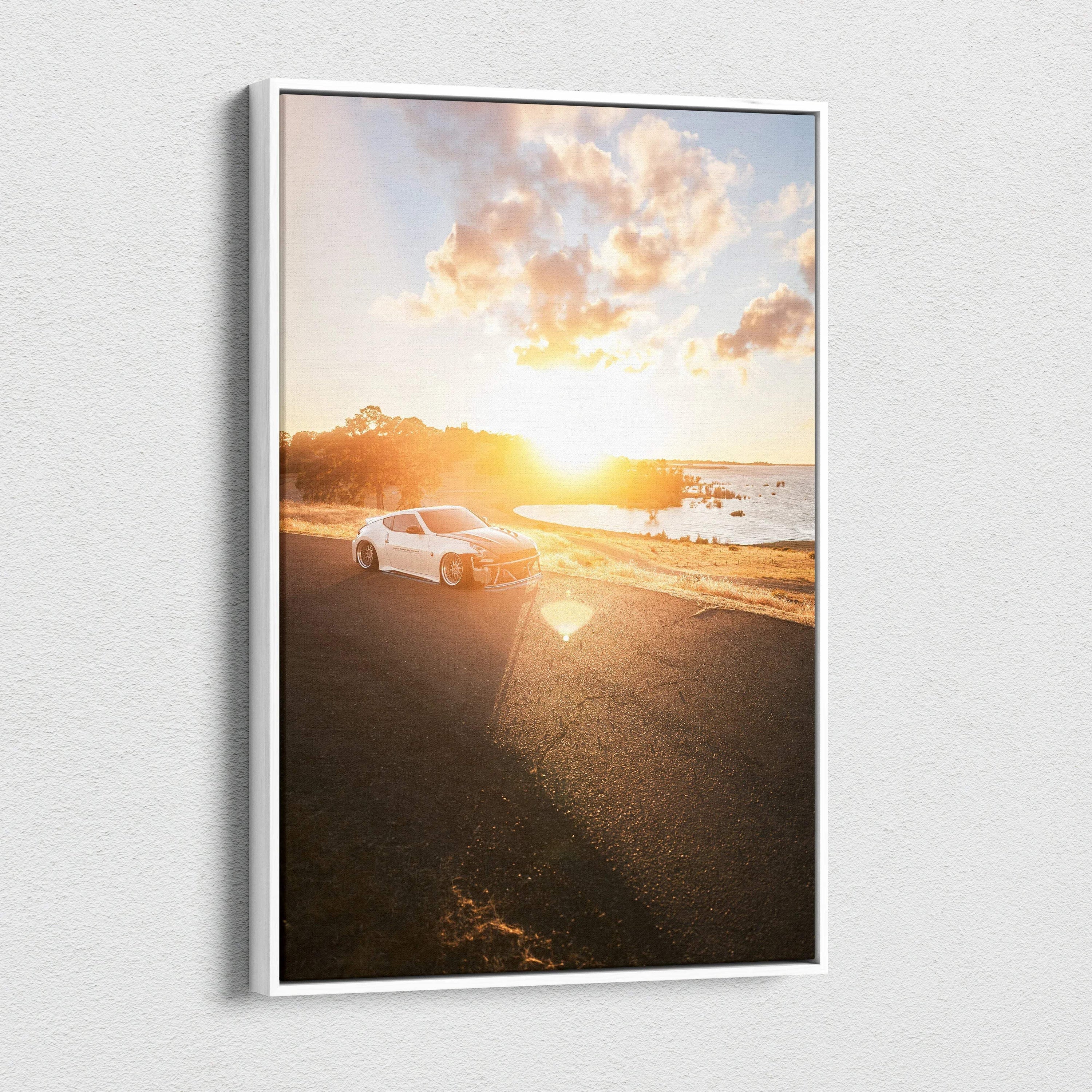 Vertical canvas art of a Nissan 370z parked by a sunlit coastal road at sunset.