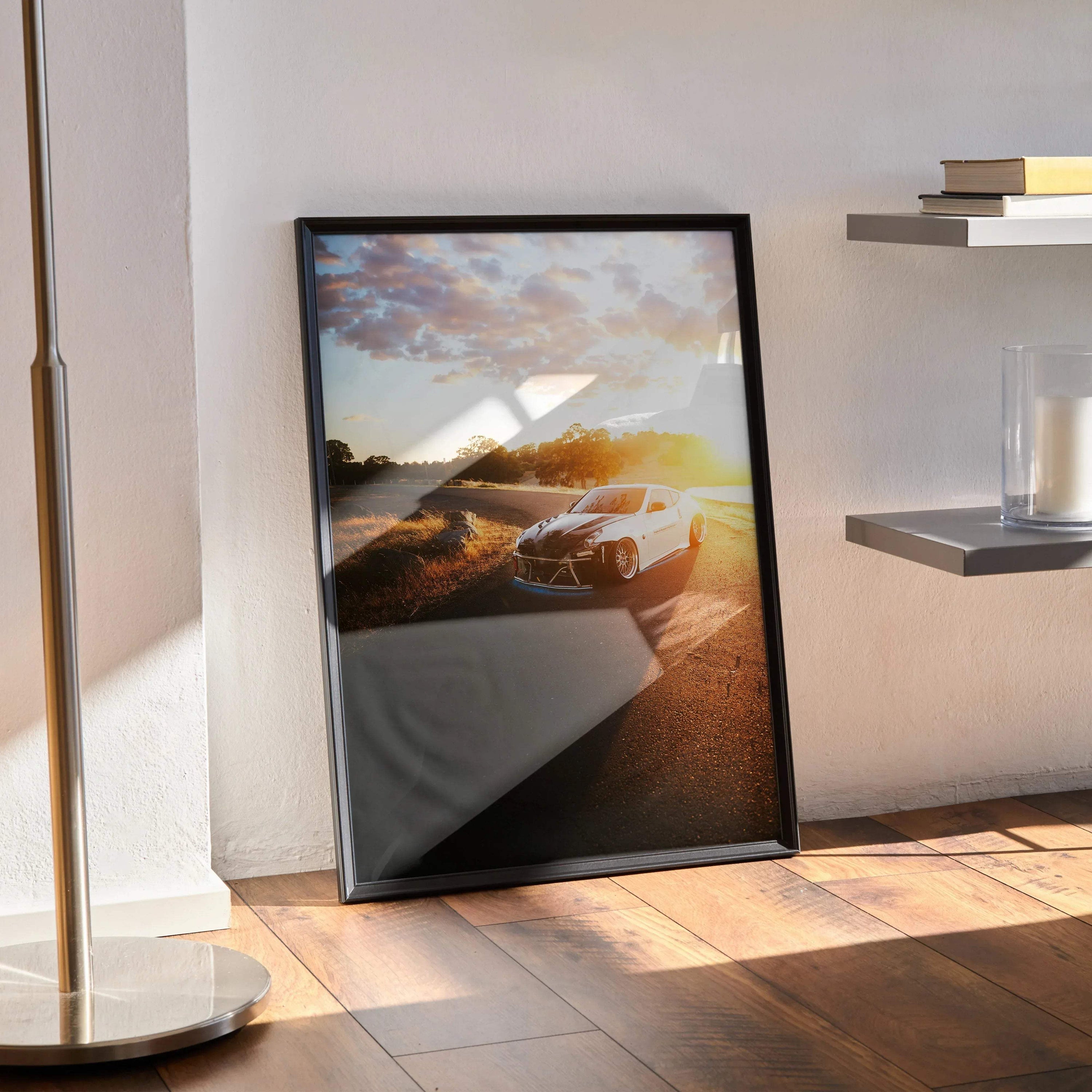 Nissan 370z sports car poster with sunset background framed wall art leaning against white wall.