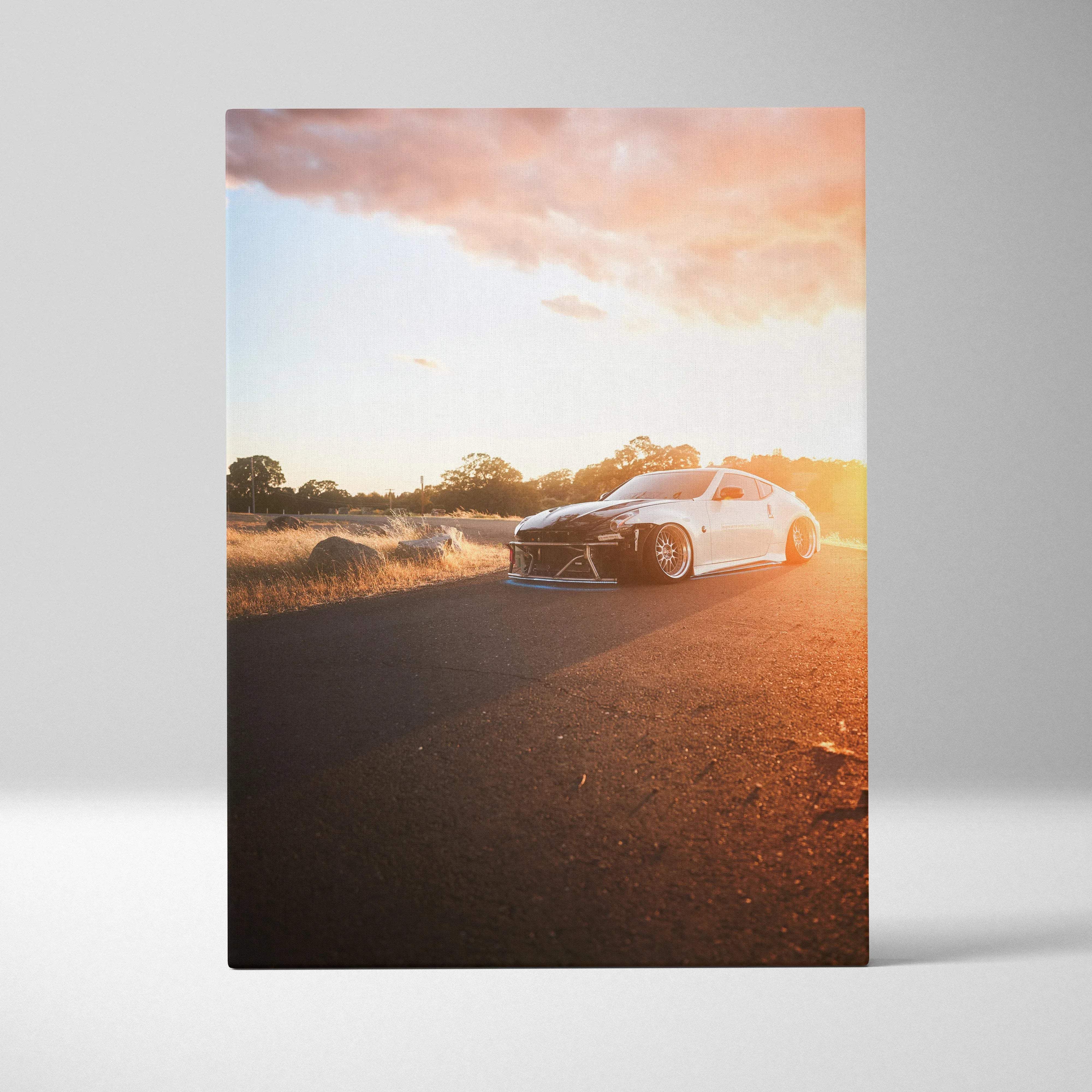 Canvas wall art automotive portrait featuring a white and black nissan 370z with lowered suspension and gold rims at sunset