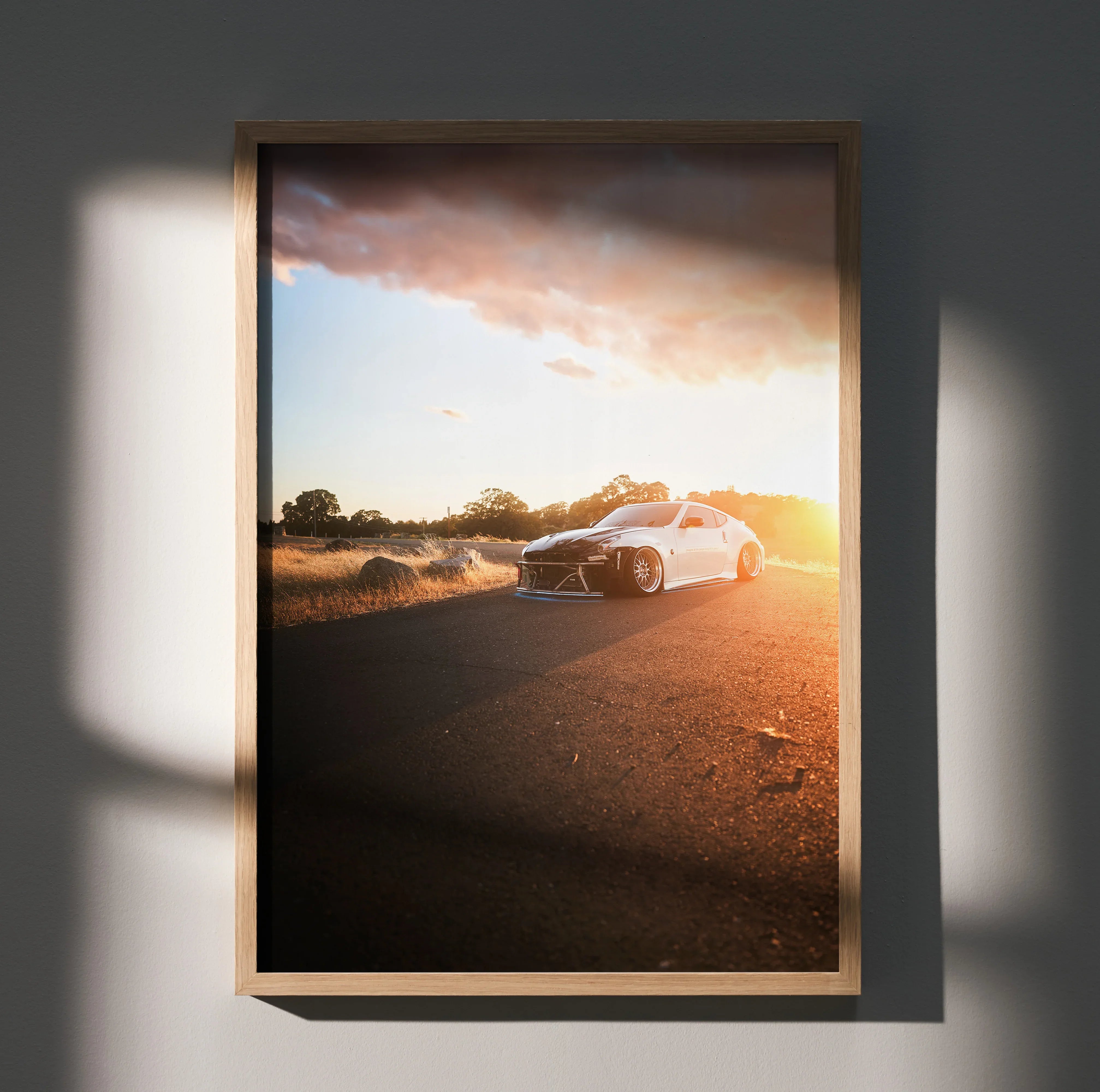 Nissan 370z car poster with sunset background framed as wall art in brown wood frame.