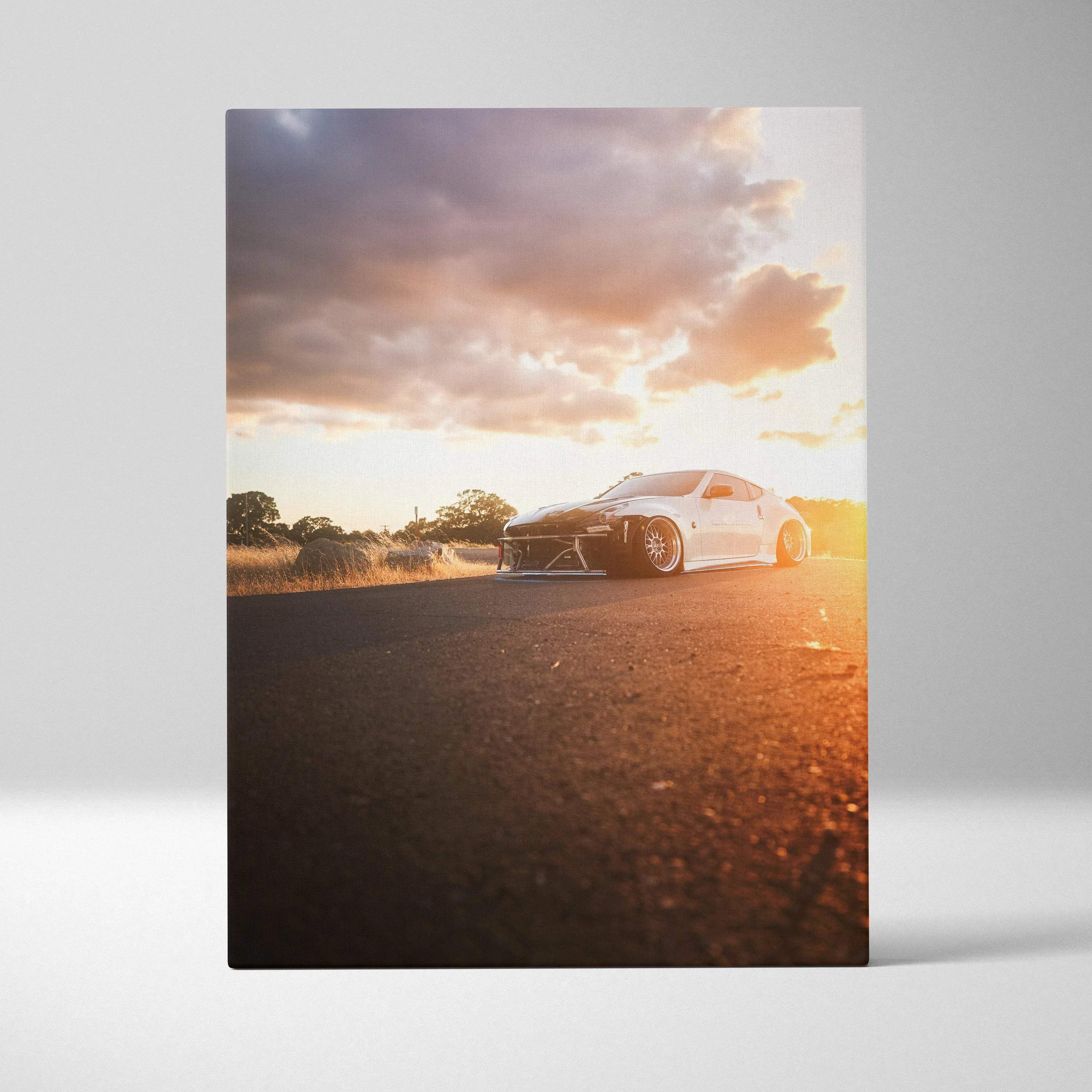 Vertical canvas wall art of white Nissan 370z on road at sunset with dramatic sky.